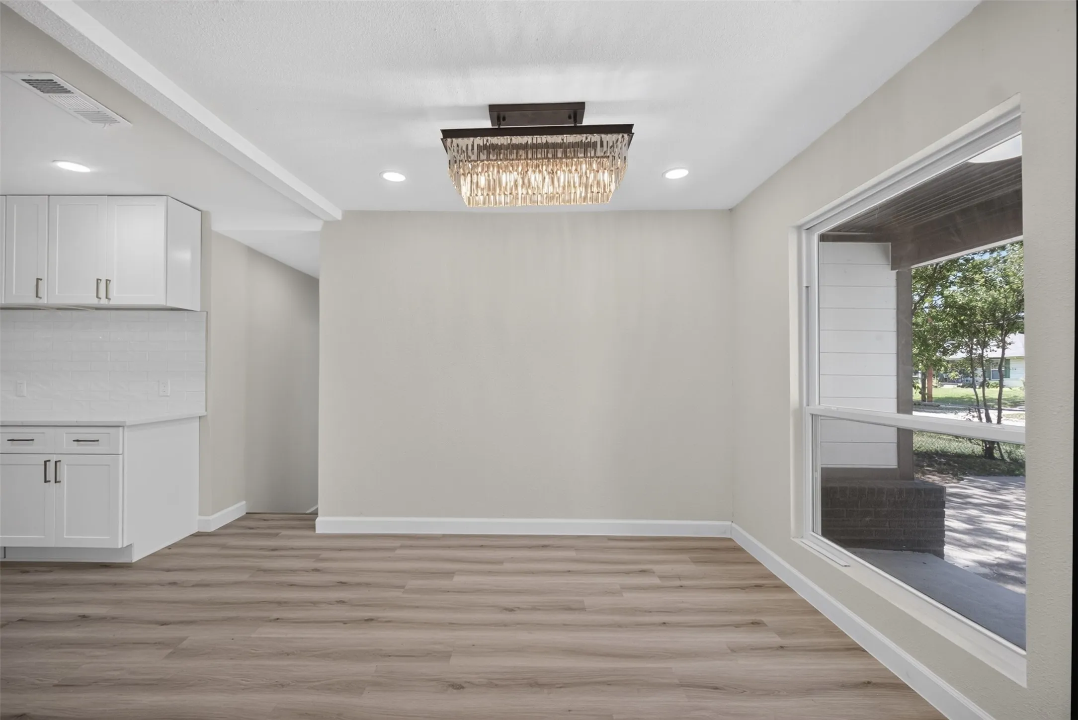Open concept space featuring light wood-finish flooring, white baseboards, and neutral wall tones