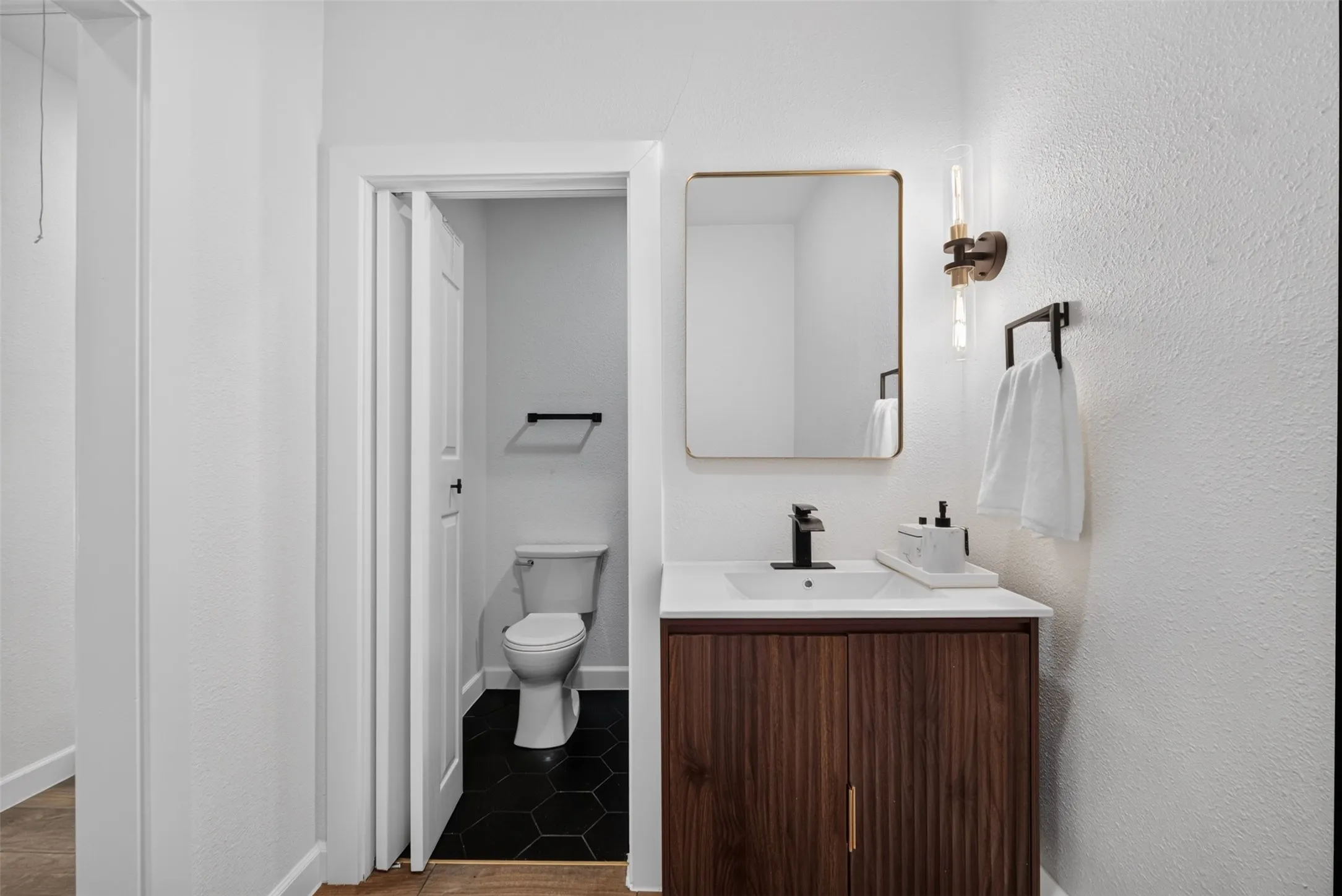 Modern vanity featuring wood-finish cabinetry, a white countertop, and a rectangular undermount sink