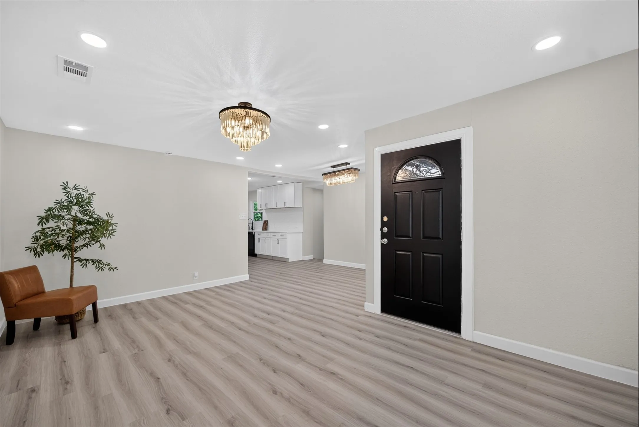 Entry space featuring a black paneled door with a decorative arched window