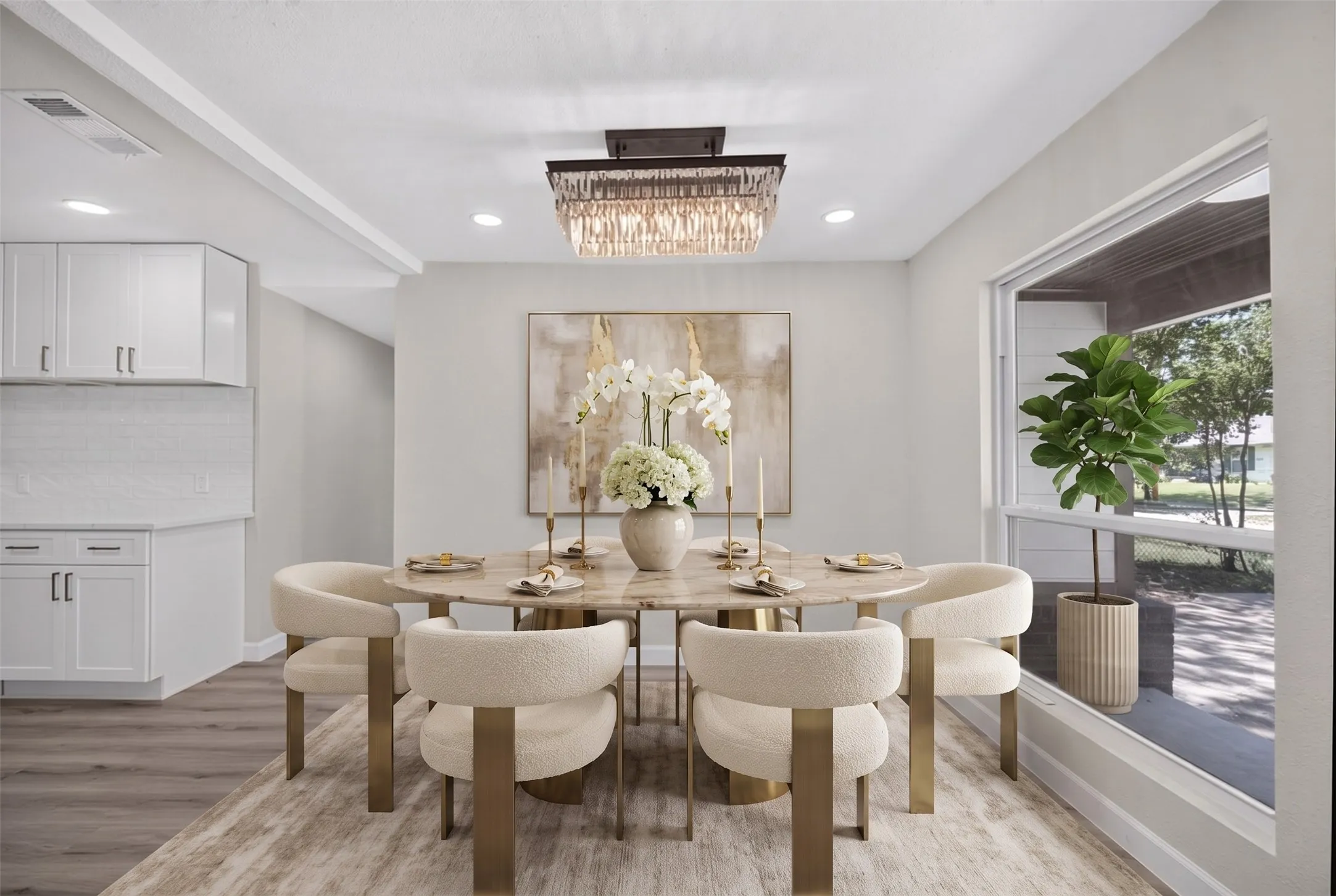 Dining area featuring a contemporary chandelier, a large window, recessed lighting, wood-finish flooring, and a portion of a kitchen with white cabinetry and a tile backsplash