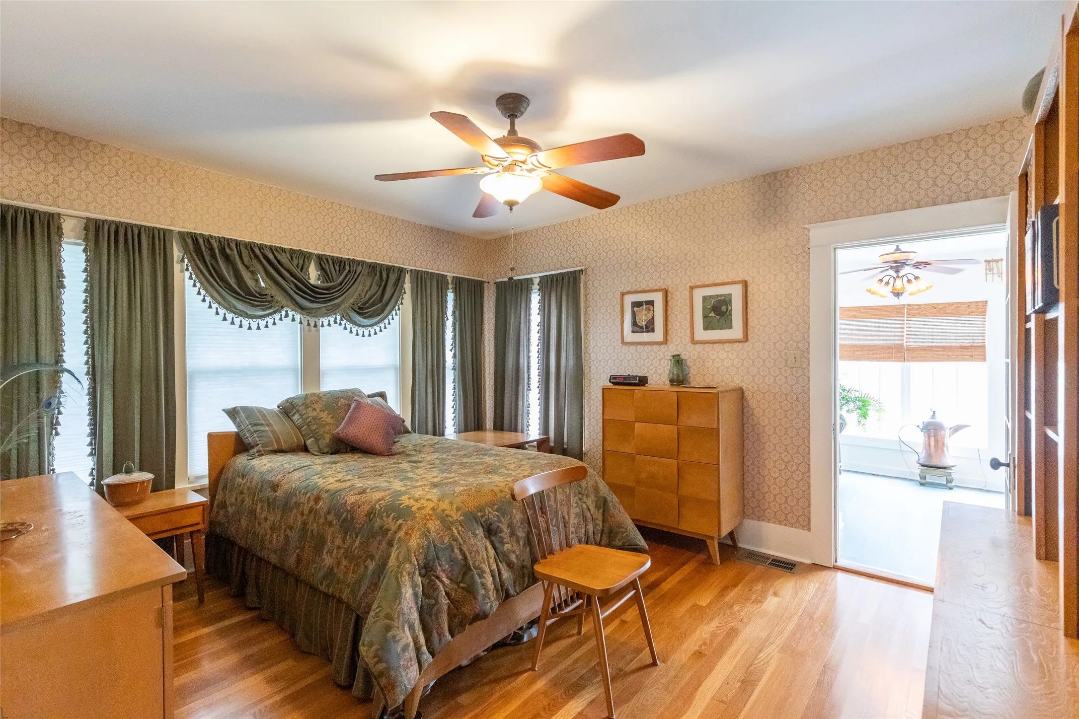 Hardwood flooring throughout, complemented by a ceiling fan with integrated lighting