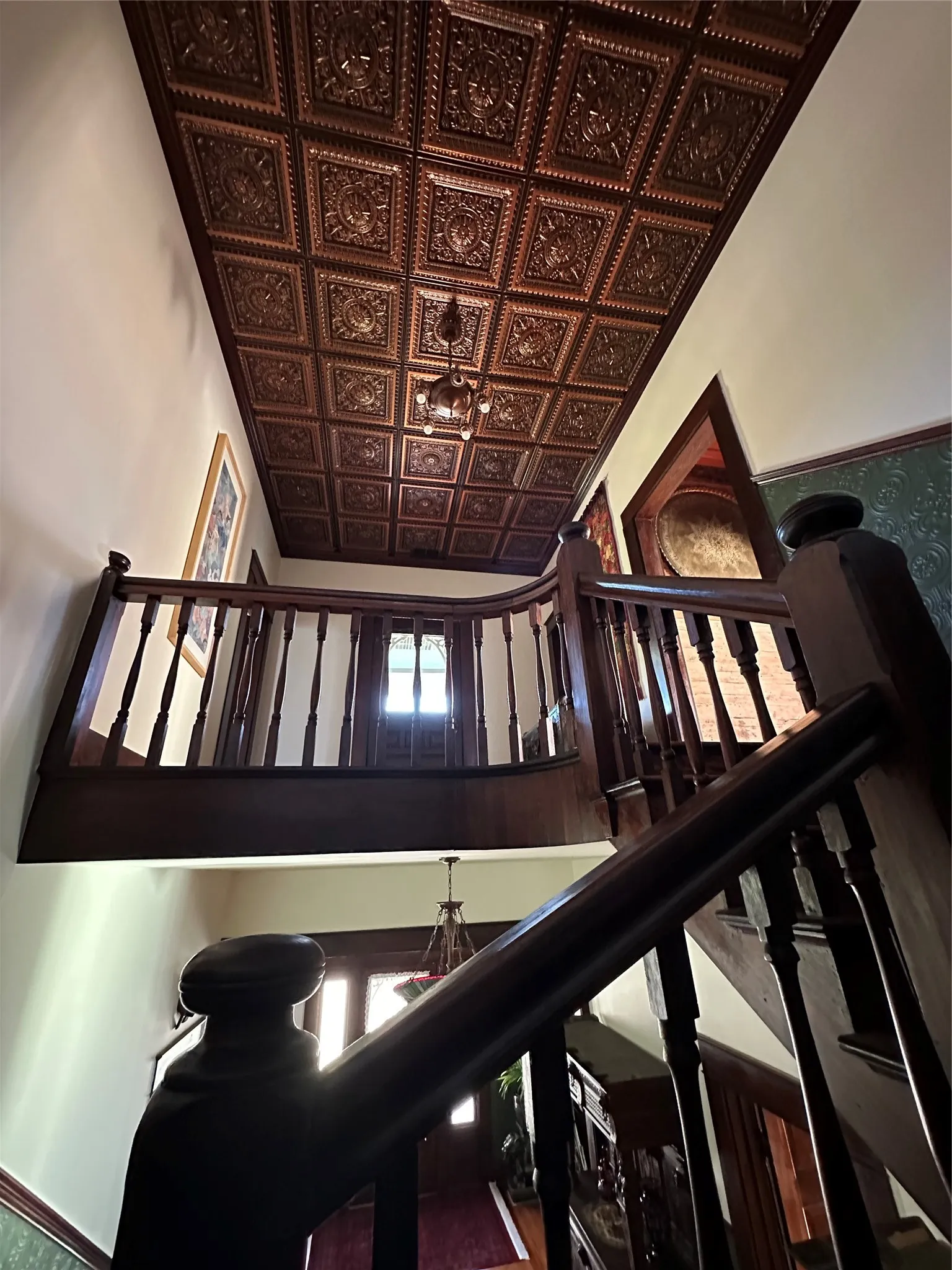 Ornate tin ceiling panels with a central chandelier