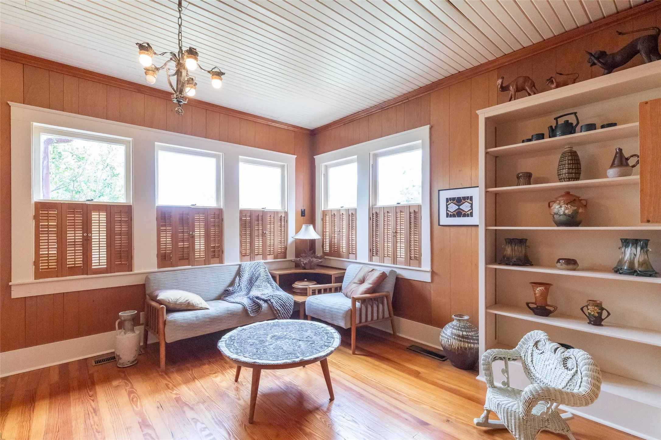 Room featuring wood-finish flooring, paneled walls, and a white beadboard ceiling