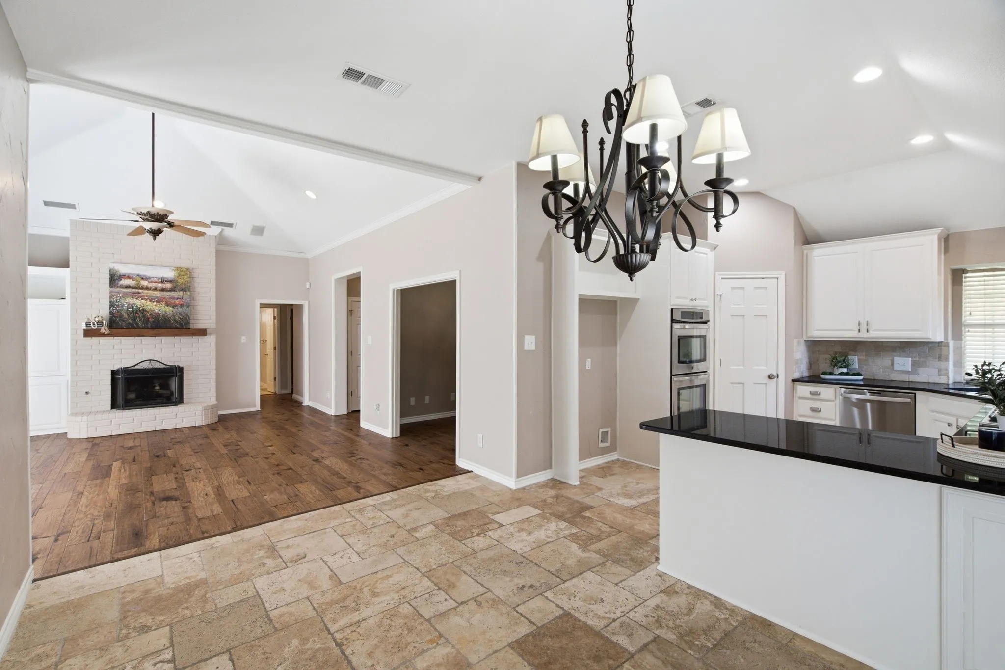 Kitchen and living area featuring a vaulted ceiling and a wood-finish floor