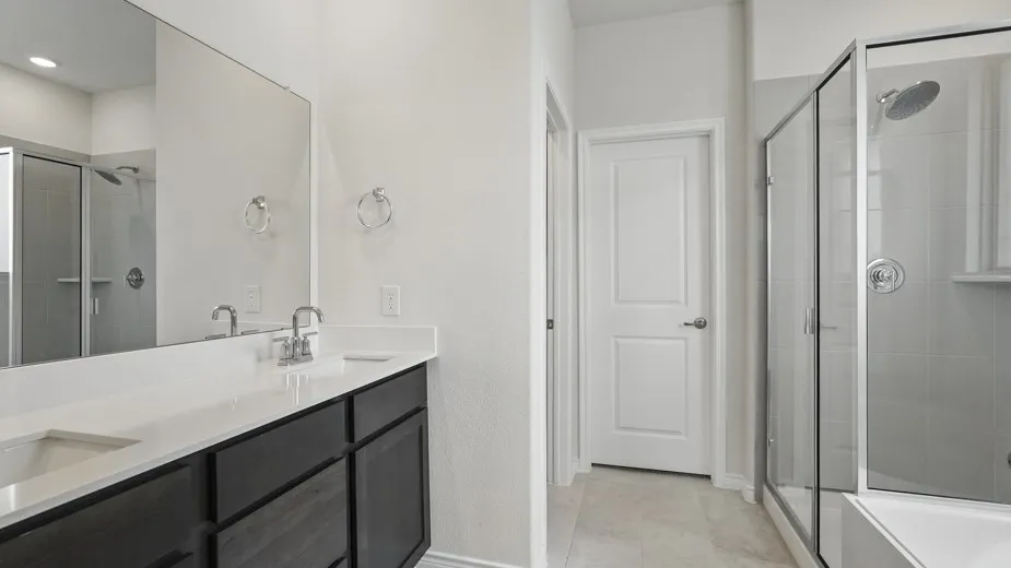 Dual vanity with an integrated white countertop, dark wood-finish cabinetry, and chrome fixtures
