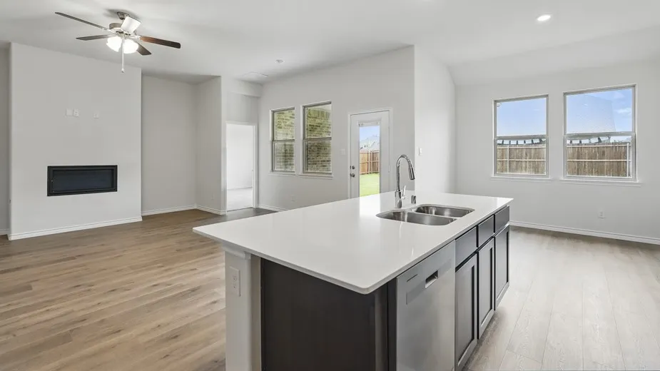 Open-concept living area featuring wood-finish flooring, a contemporary built-in fireplace, and a ceiling fan