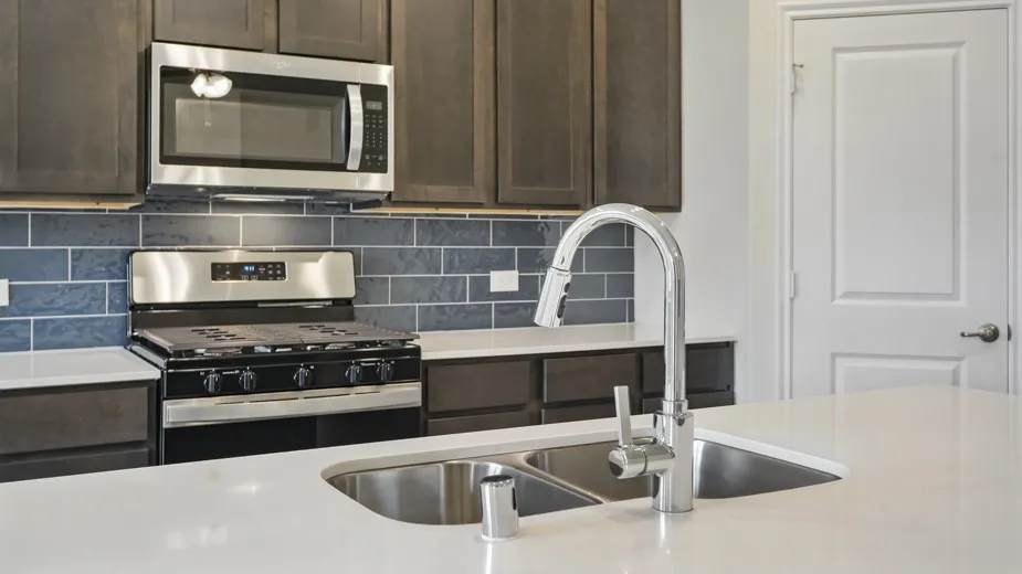 Kitchen island featuring a double basin stainless steel sink with a high-arch chrome faucet