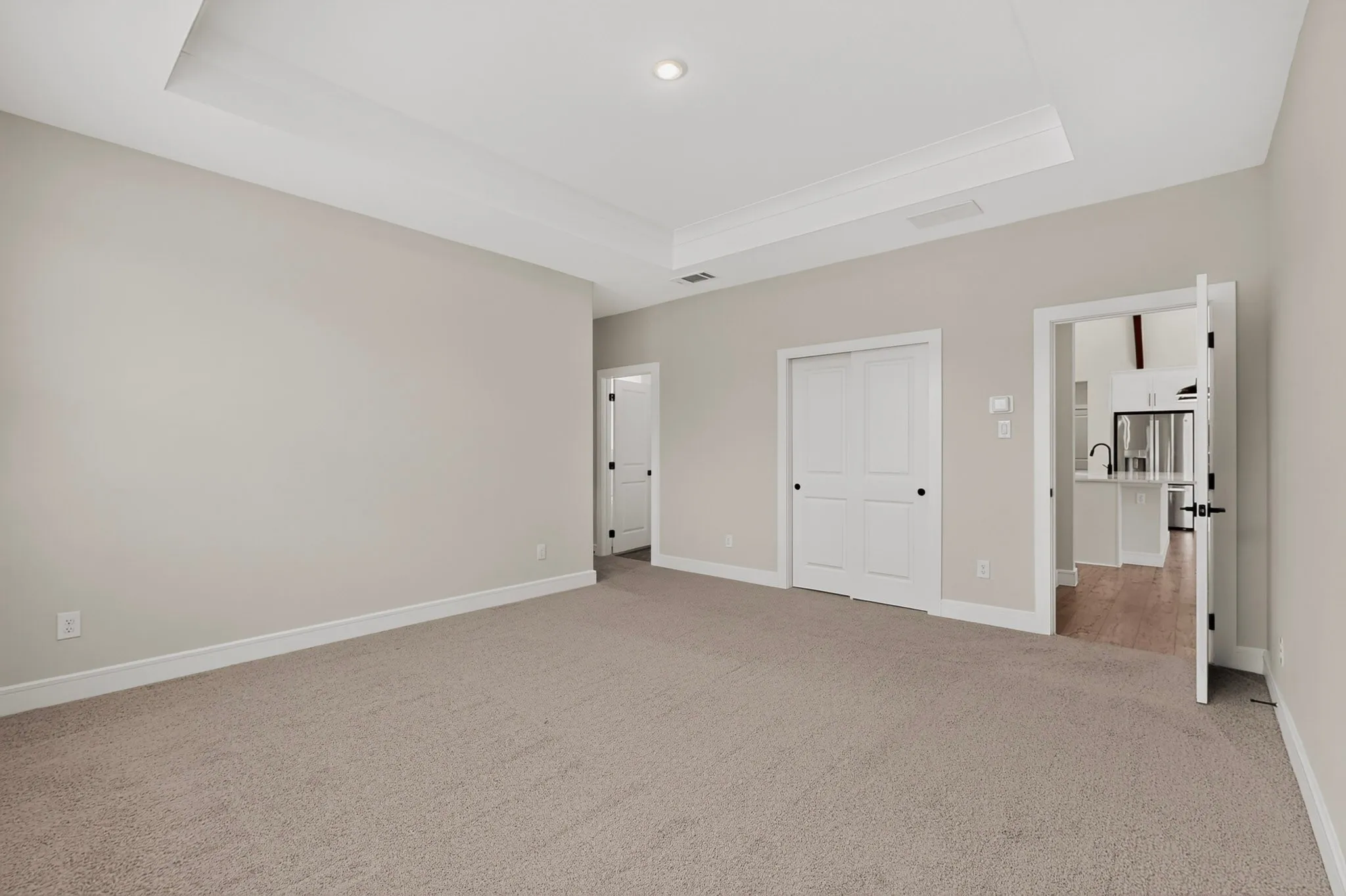 Tray ceiling with crown molding, recessed lighting, carpeted flooring, multiple windows