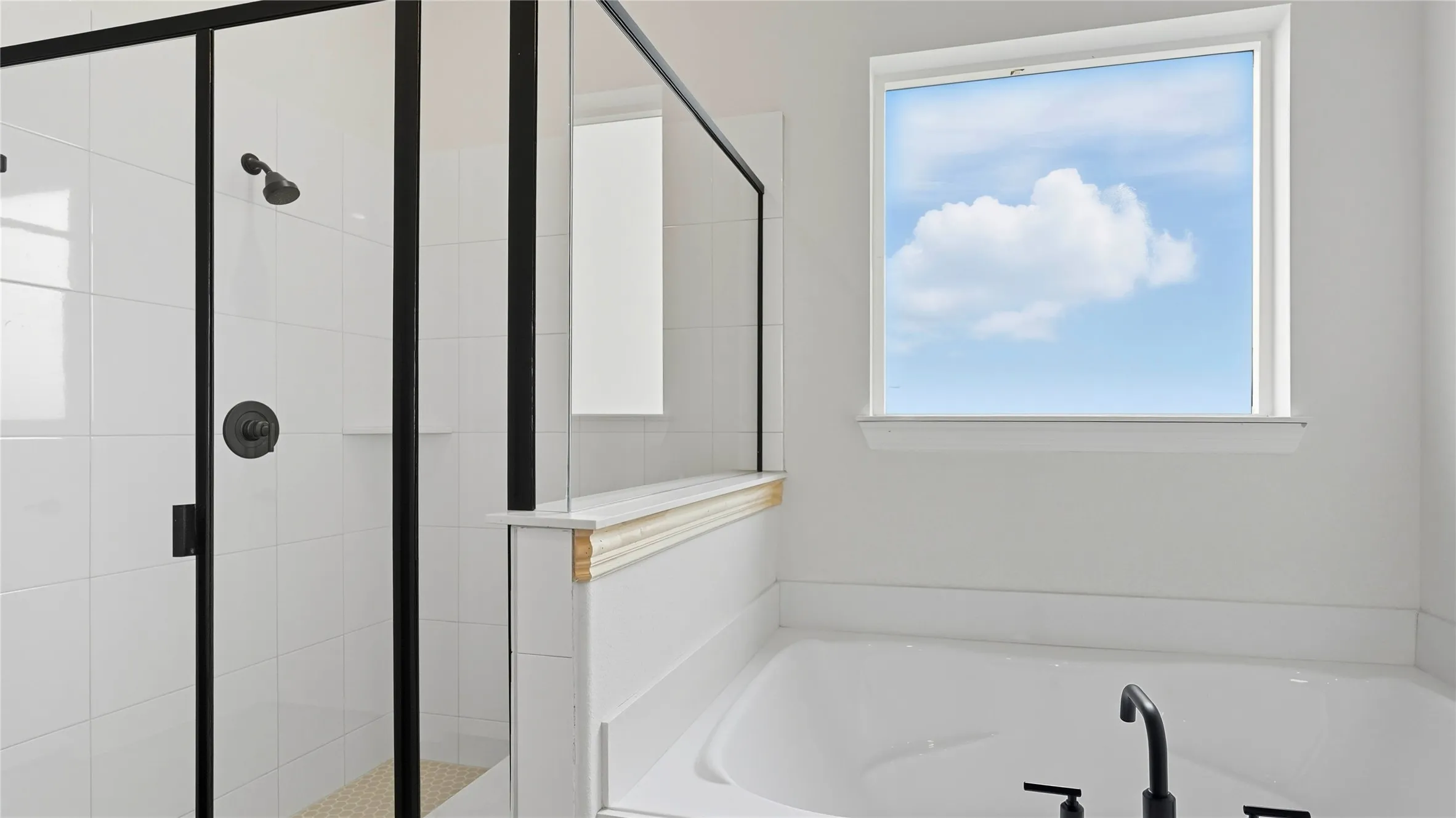 Full bathroom featuring a rectangular soaking tub with matte black fixtures, a window above the tub, and a shower with black-framed glass enclosure
