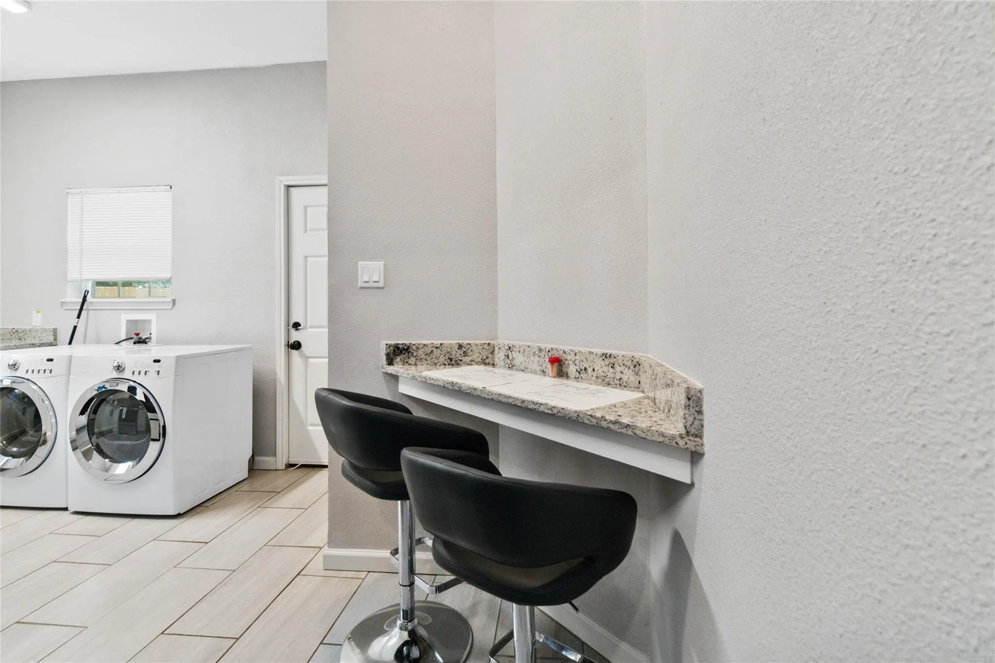 Clothes washing area with baseboards, laundry area, independent washer and dryer, and wood tiled floor