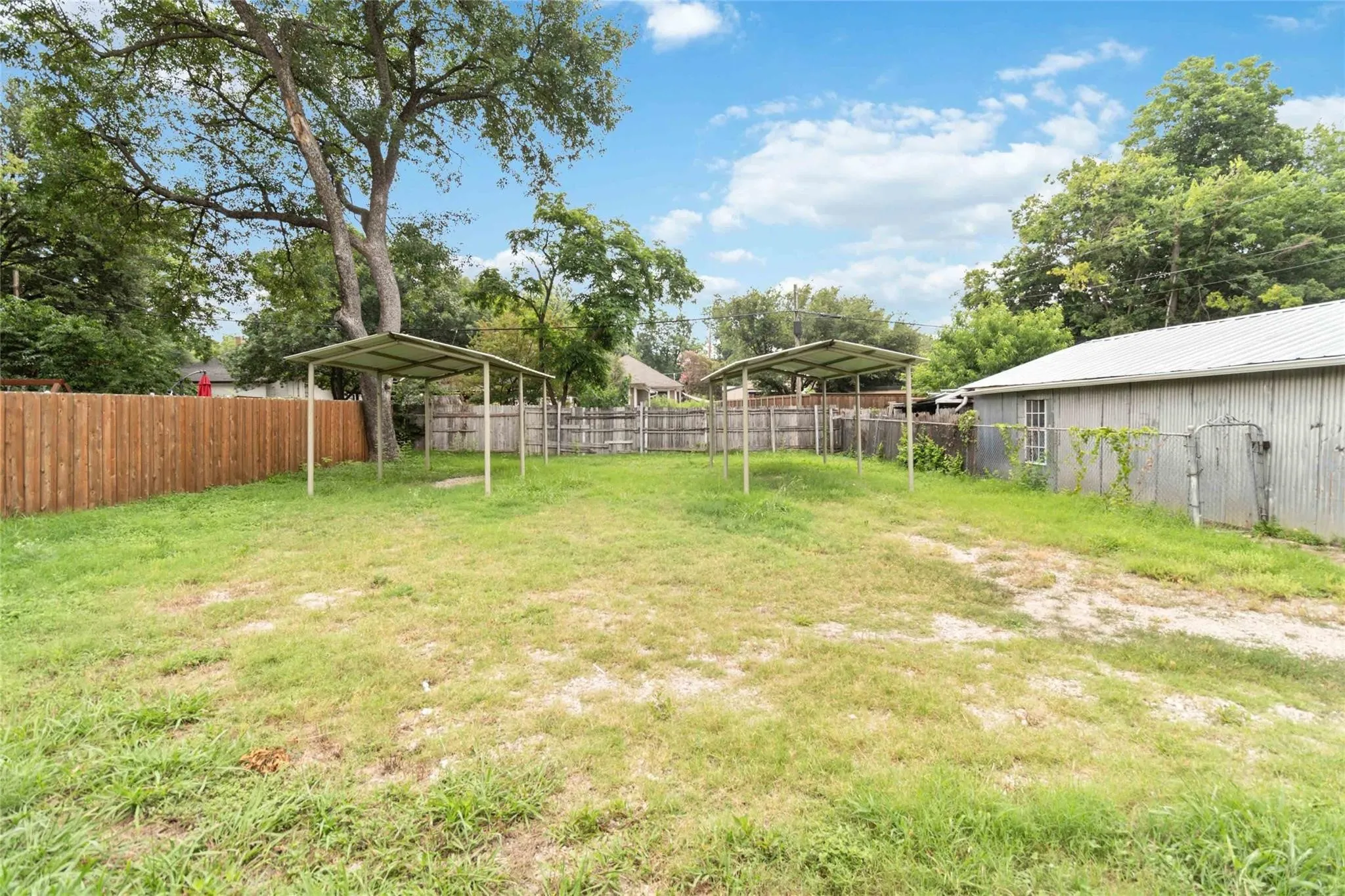 View of yard with a carport and a fenced backyard