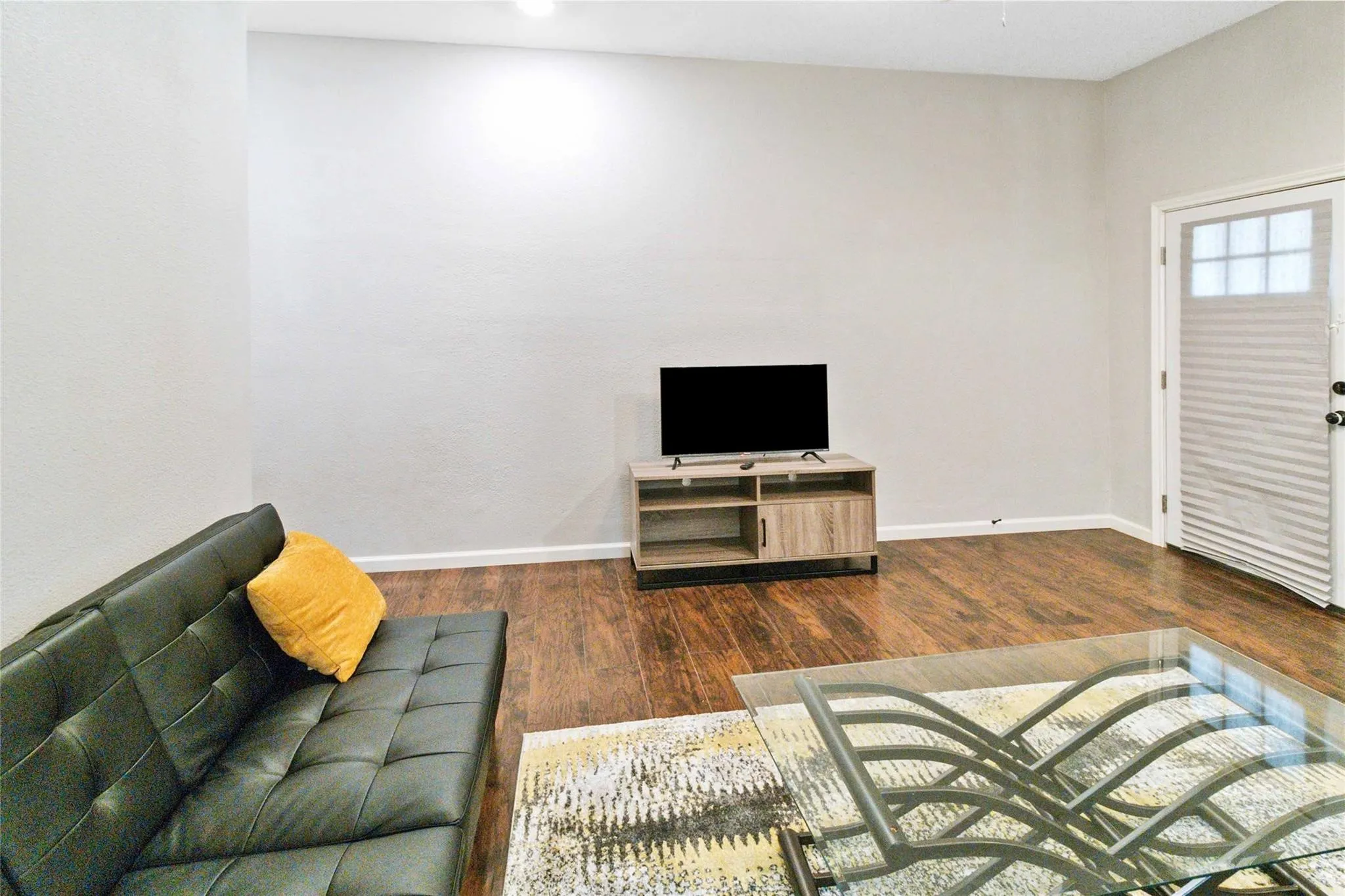Living room featuring dark wood-style floors and baseboards