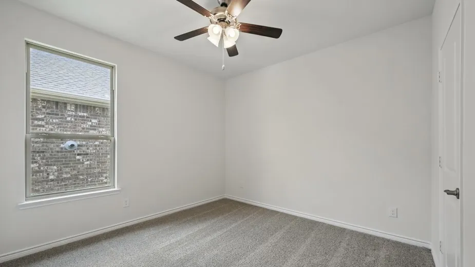 Room featuring neutral carpet flooring, white walls, a multi-speed ceiling fan with integrated lighting, and a double-hung window with white trim