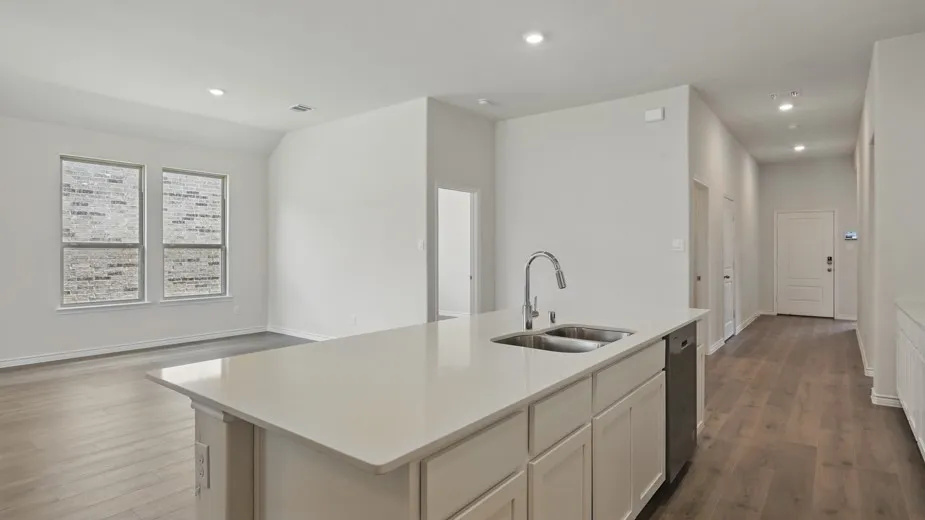 Kitchen island with a dual basin sink, integrated dishwasher, and a gooseneck faucet