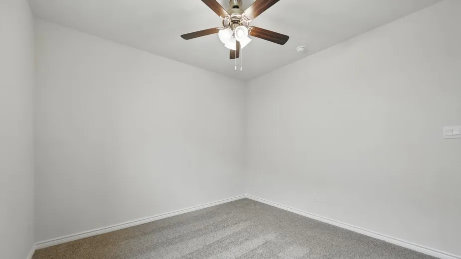 Room featuring light gray carpeting, neutral wall paint, and a ceiling fan with light fixture