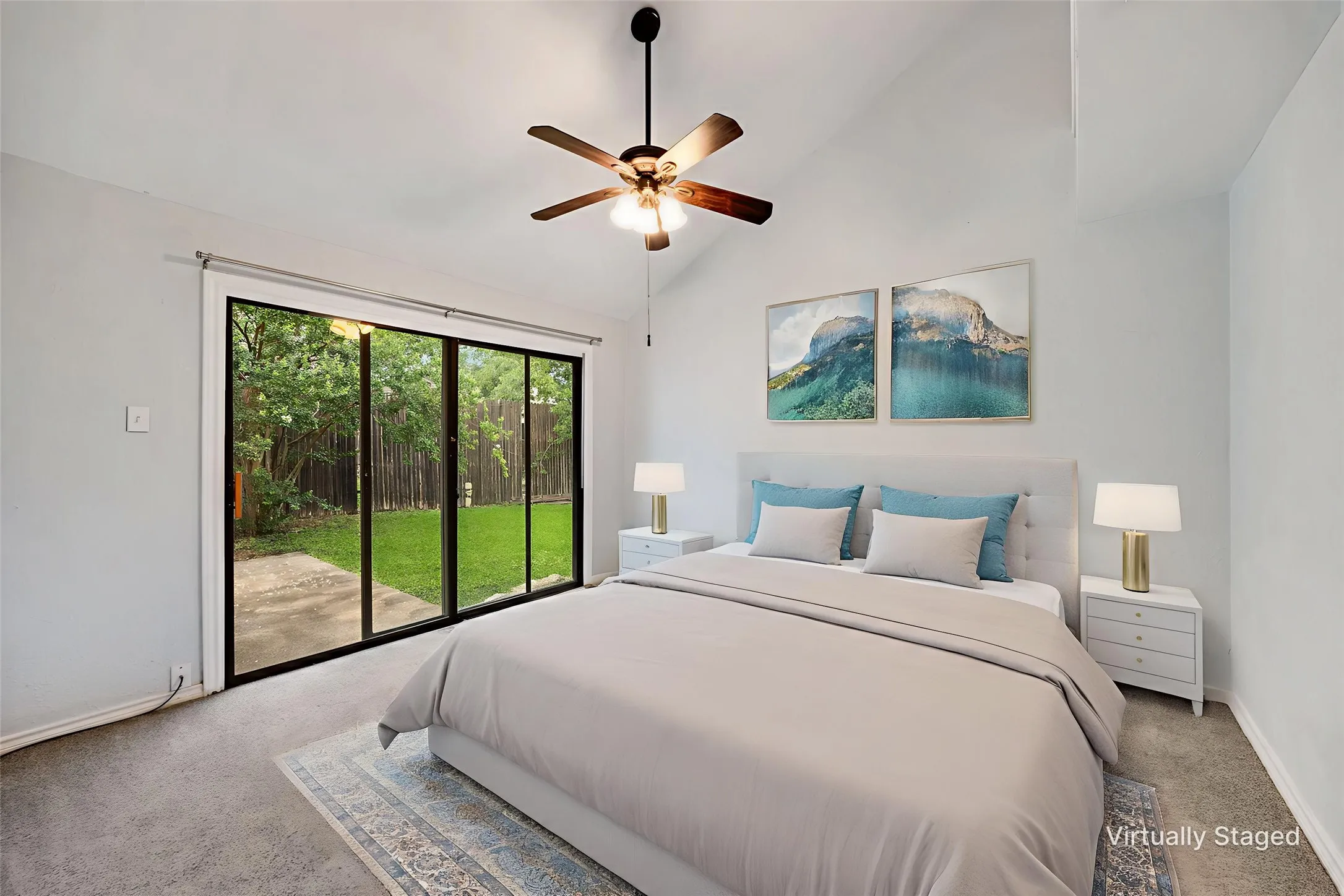 Vaulted ceilings with a ceiling fan, sliding glass doors, and a private patio space