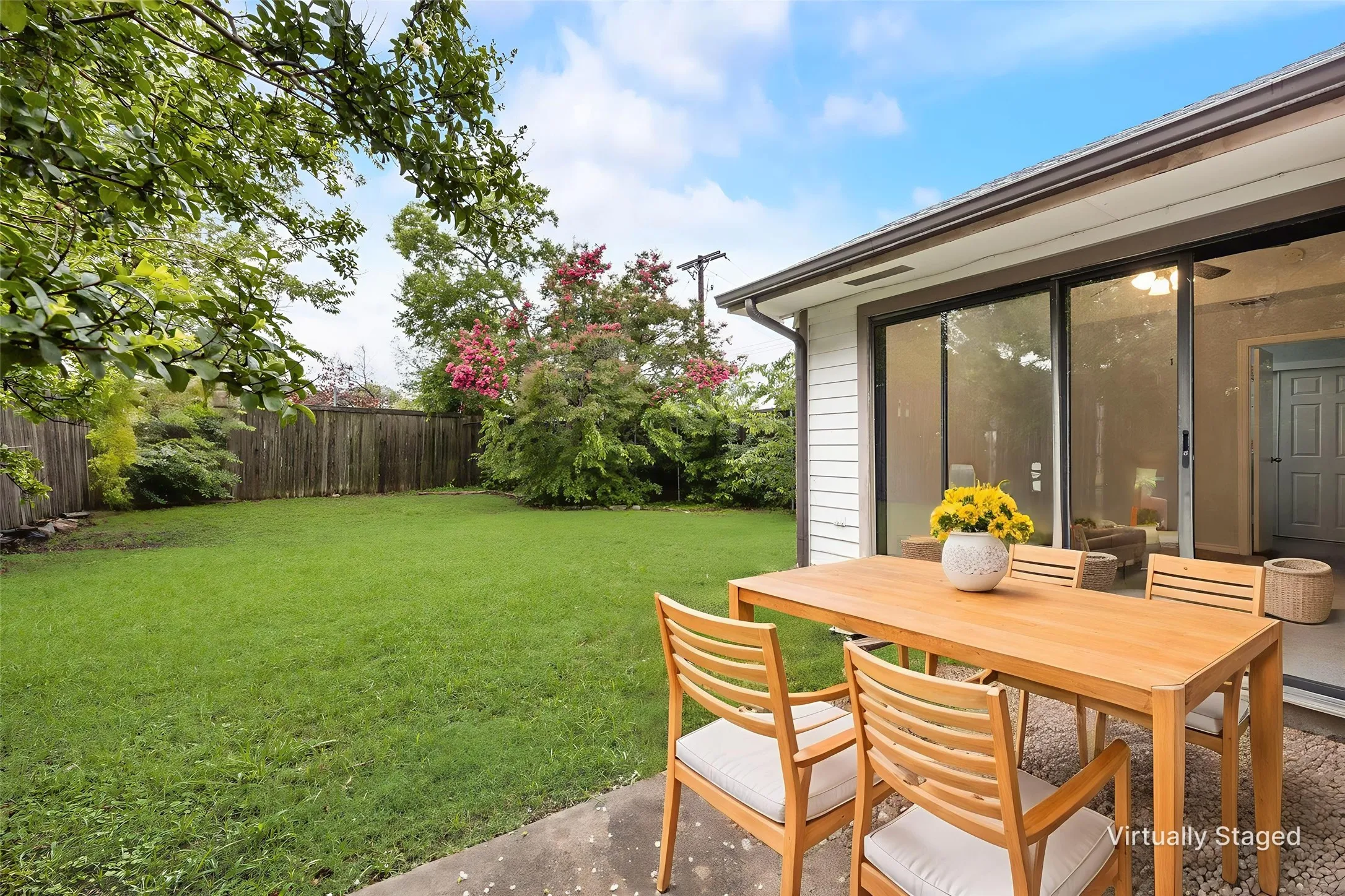 Expansive backyard featuring a manicured lawn, established perimeter fencing, and mature trees
