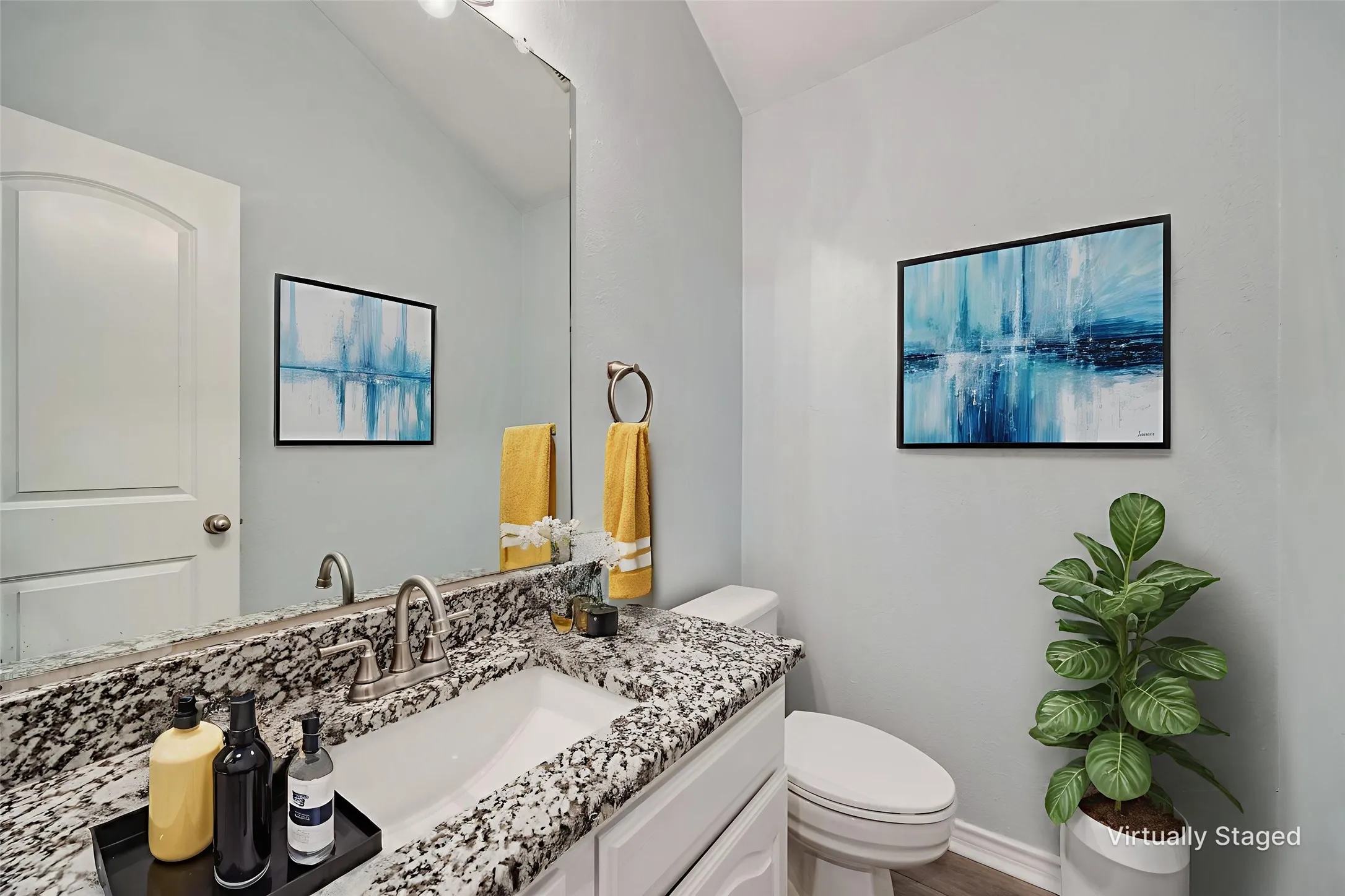Bathroom vanity featuring a speckled countertop, undermount sink, and brushed nickel faucet