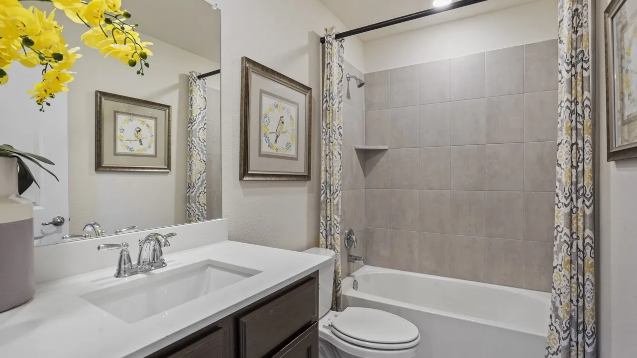 Bathroom featuring a white vanity with an integrated sink, chrome faucet, and dark wood-finish cabinetry