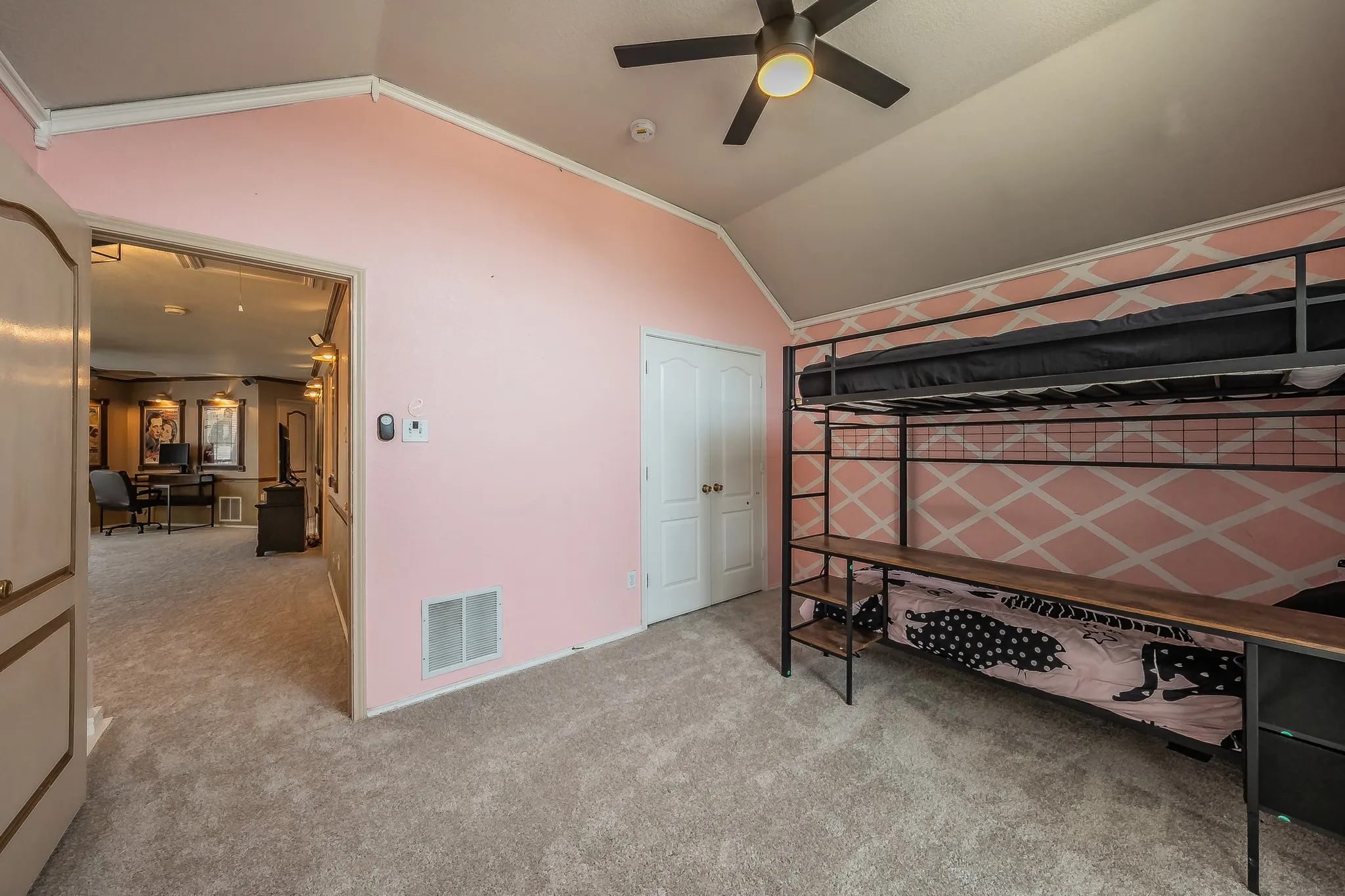 Carpeted room with a vaulted ceiling and a ceiling fan