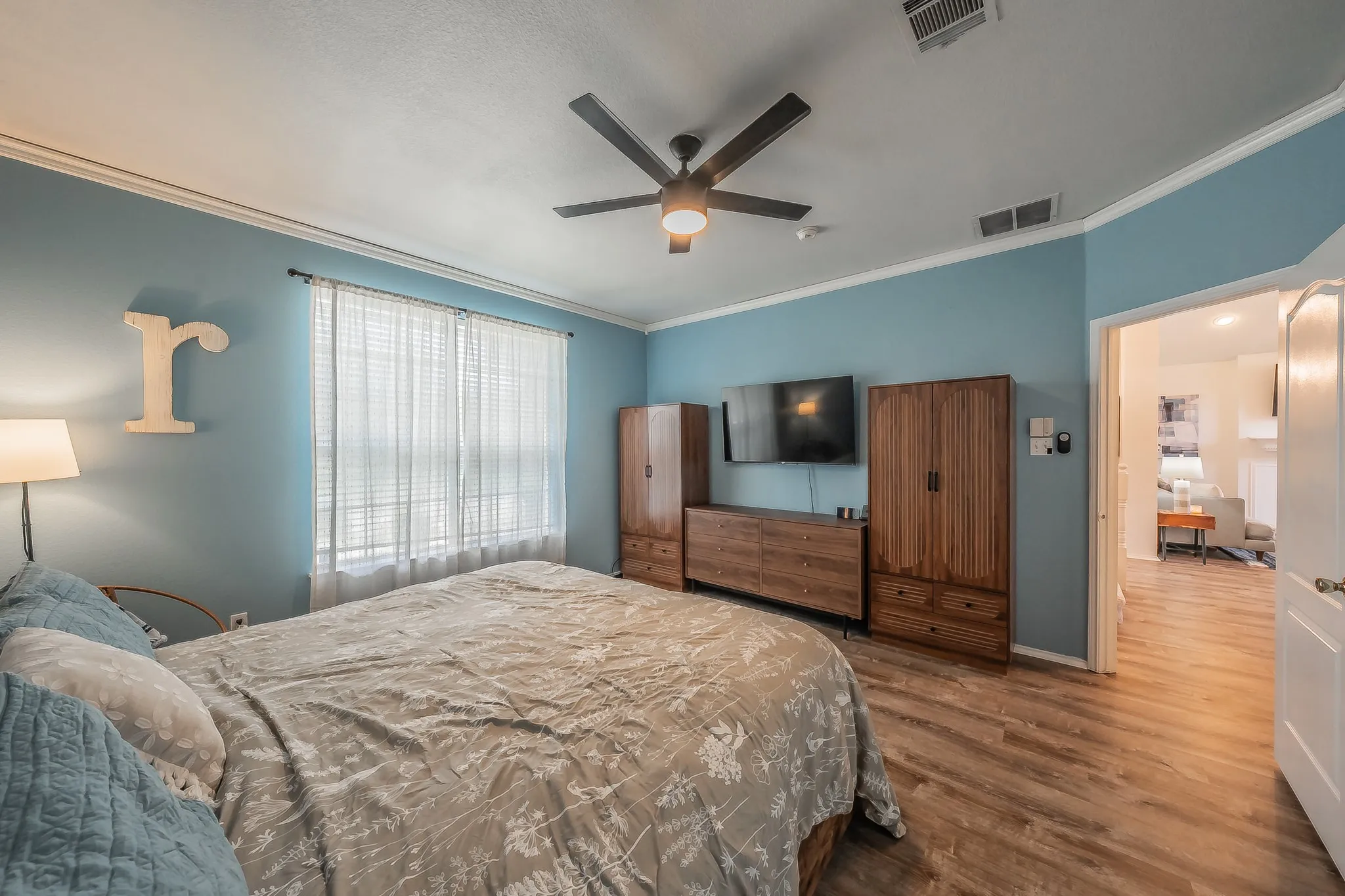 Bedroom featuring wood-finish flooring, a ceiling fan, and crown molding