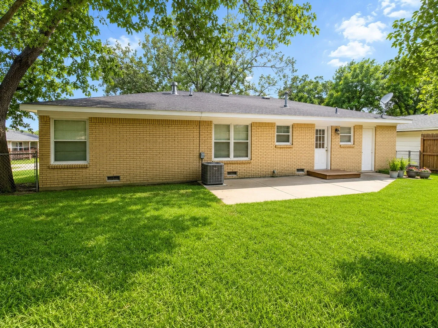 Expansive green lawn with mature shade trees