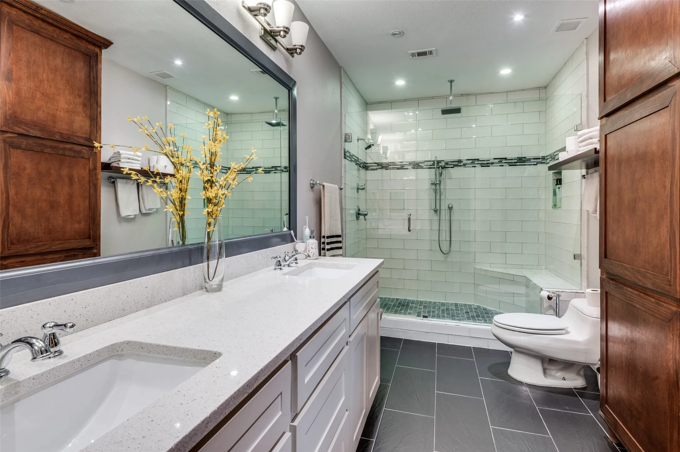 Primary bathroom with large walk-in shower and dual sinks and massive mirror