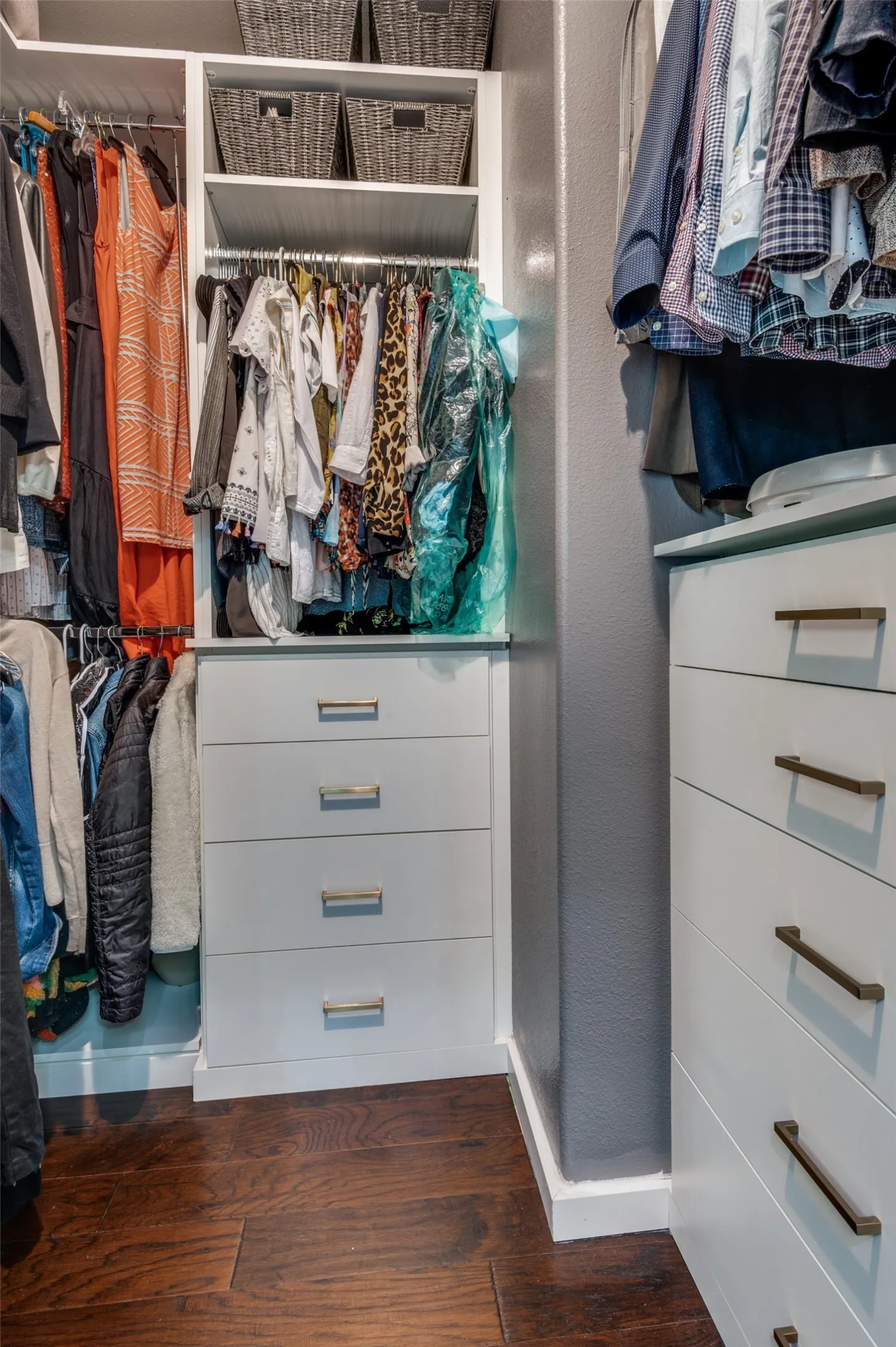Custom designed closet system in primary walk-in closet