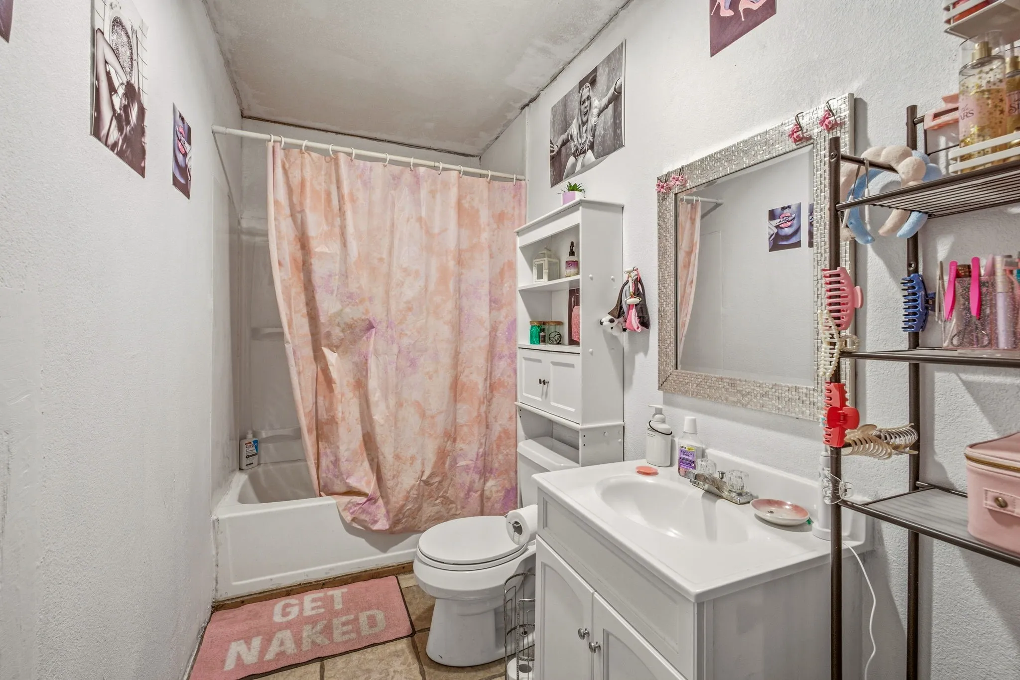Bathroom featuring a white vanity with integrated sink, a rectangular framed mirror, and a built-in shower/tub combination