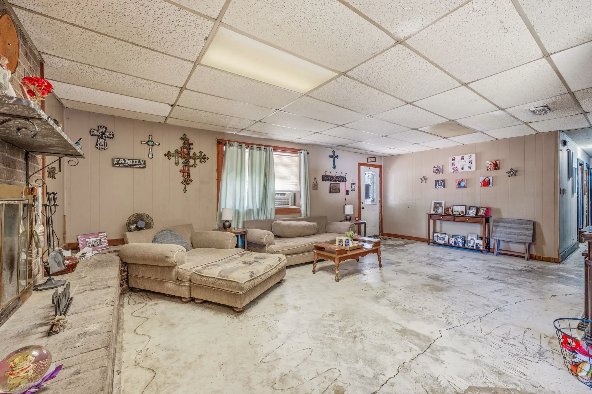 Spacious room featuring concrete flooring and light-toned wall paneling