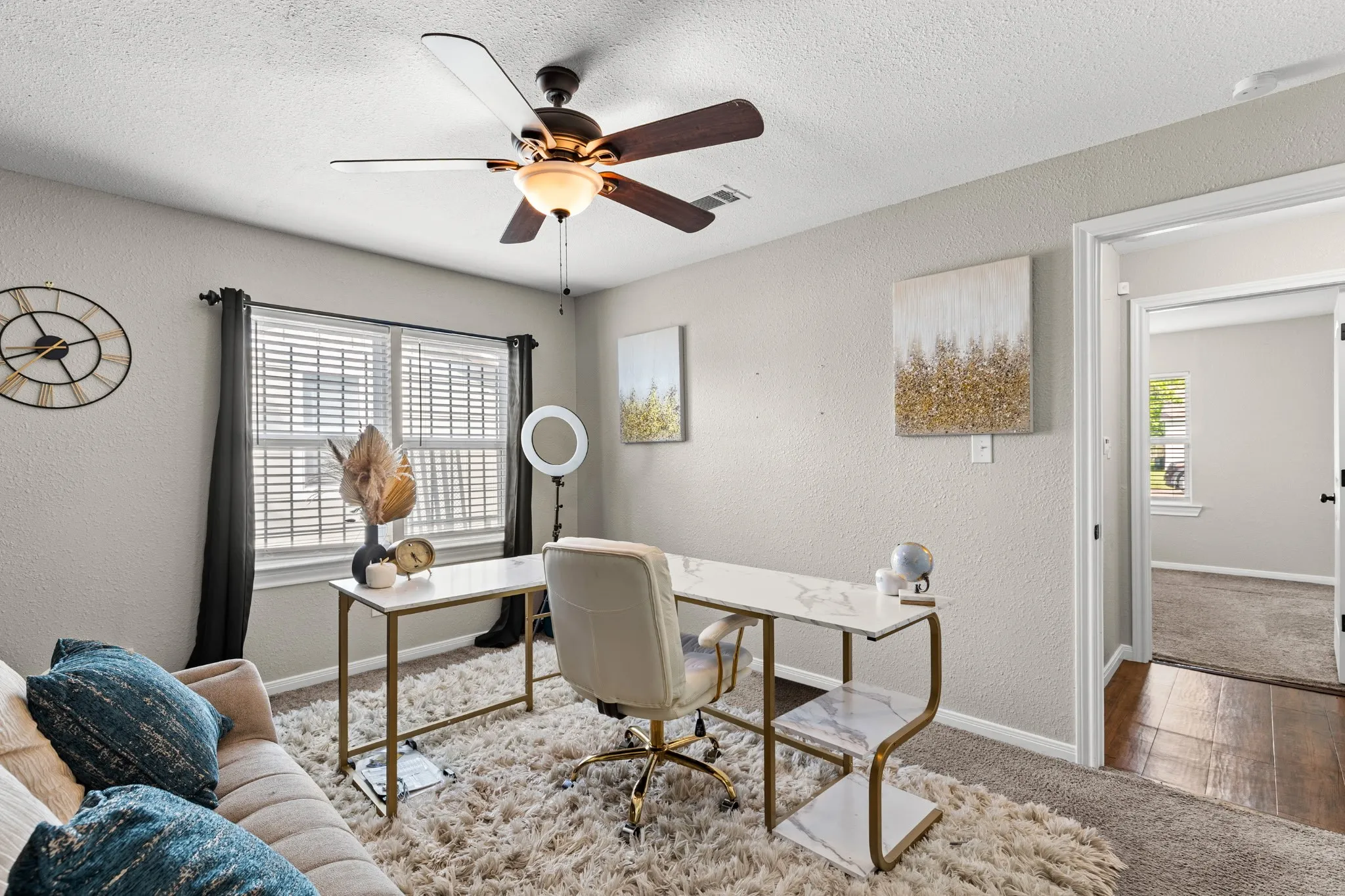 Room featuring light-colored walls, window with blinds, and a dark-bladed ceiling fan with integrated lighting