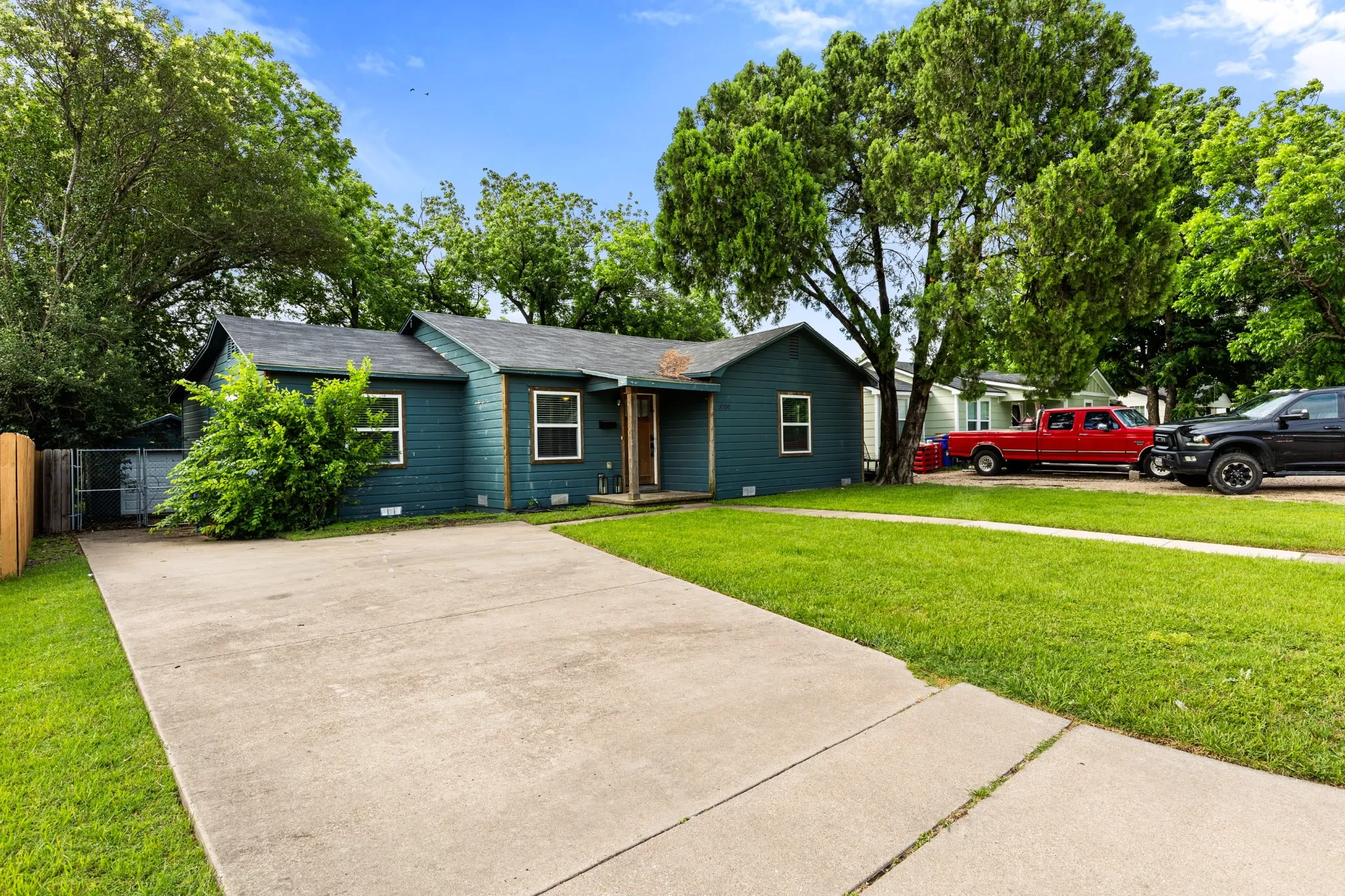 Single-story residence featuring a dark blue siding exterior, a gray shingle roof, and multiple white-trimmed windows