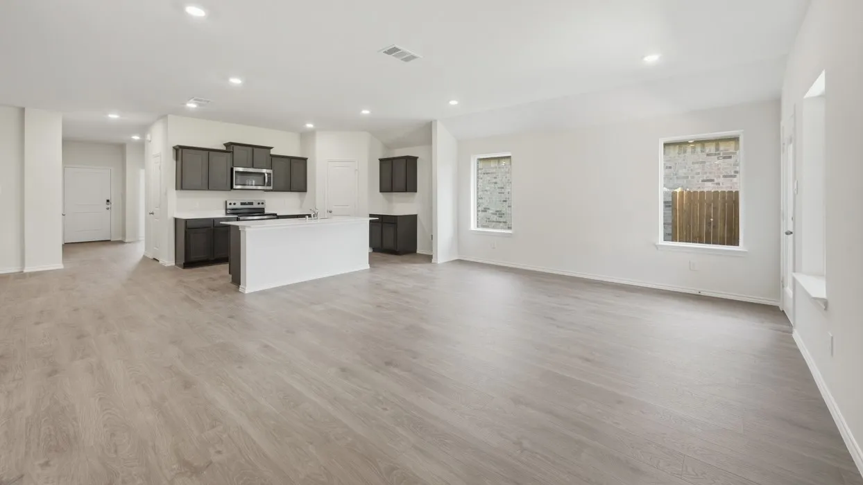 Open-concept living space featuring wood-finish flooring, recessed lighting, and white walls