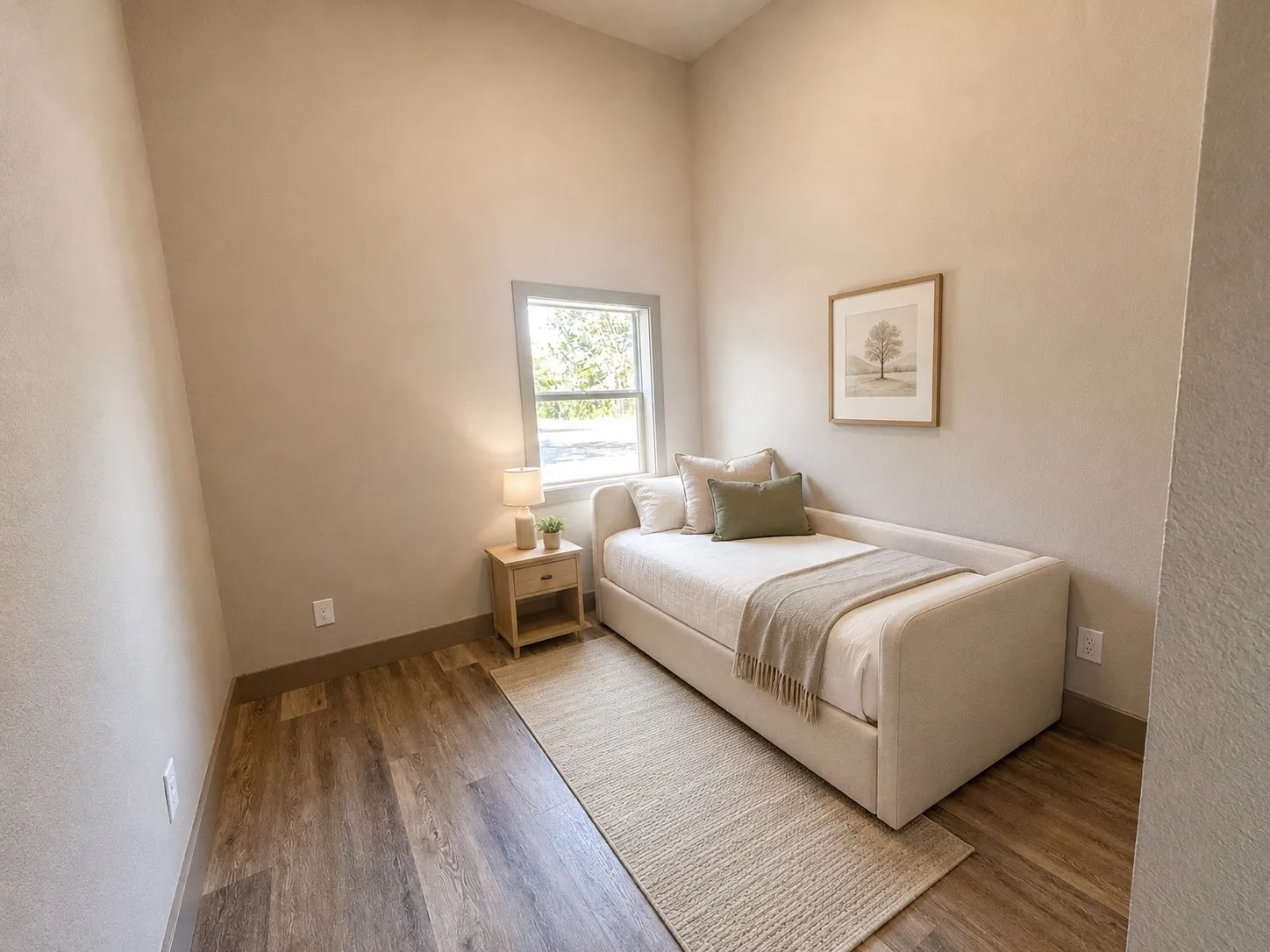 Vaulted ceiling with neutral wall finish, wood-finish flooring, and single-pane window