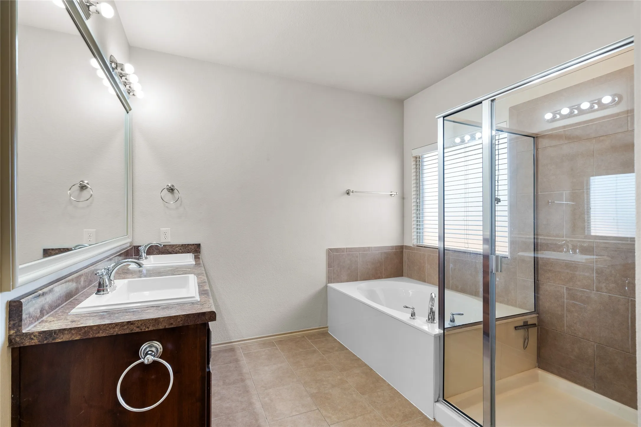 Bathroom with tile flooring, double vanity, and plus walk in shower