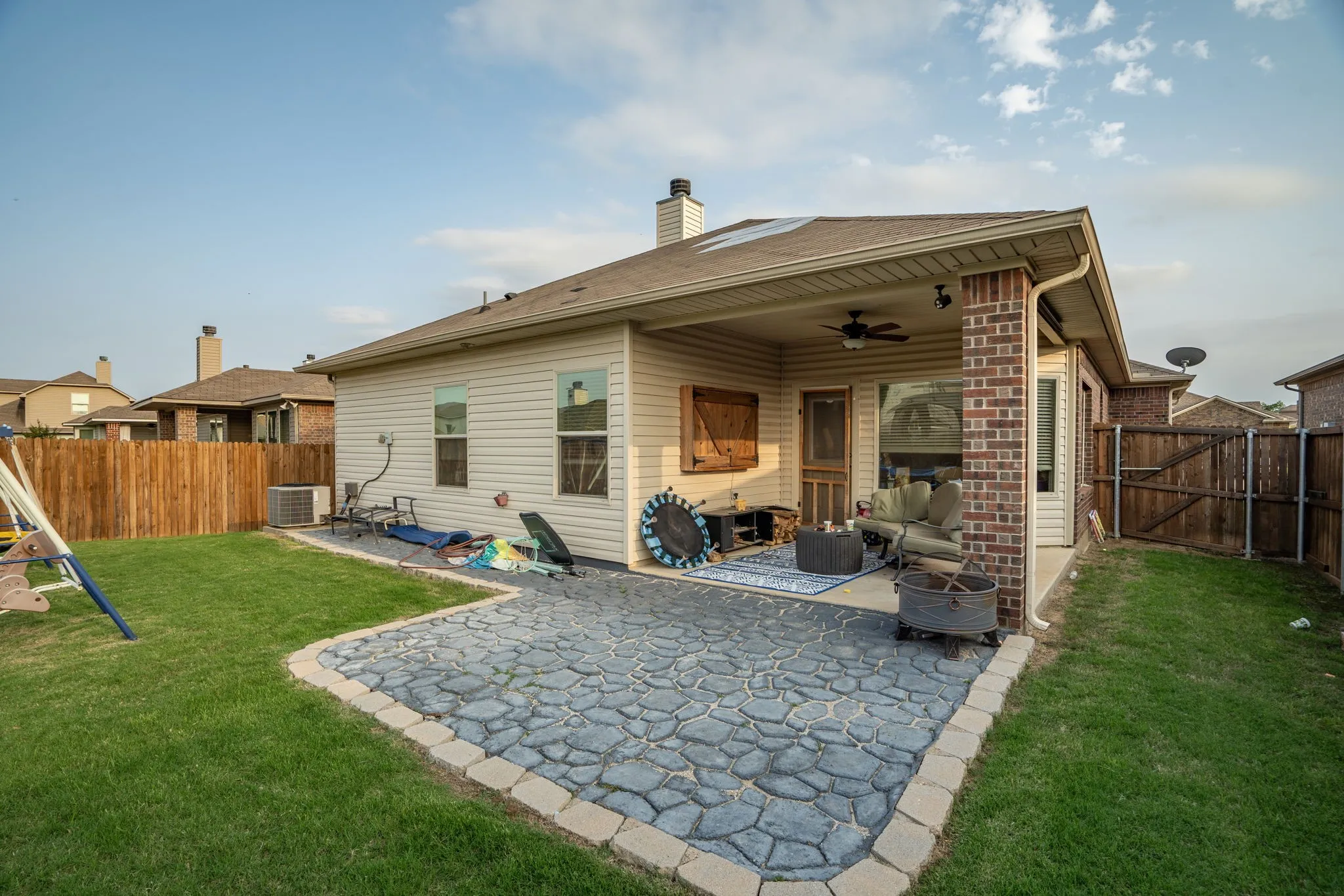 Back of house featuring ceiling fan, a lawn, central AC unit, and a patio