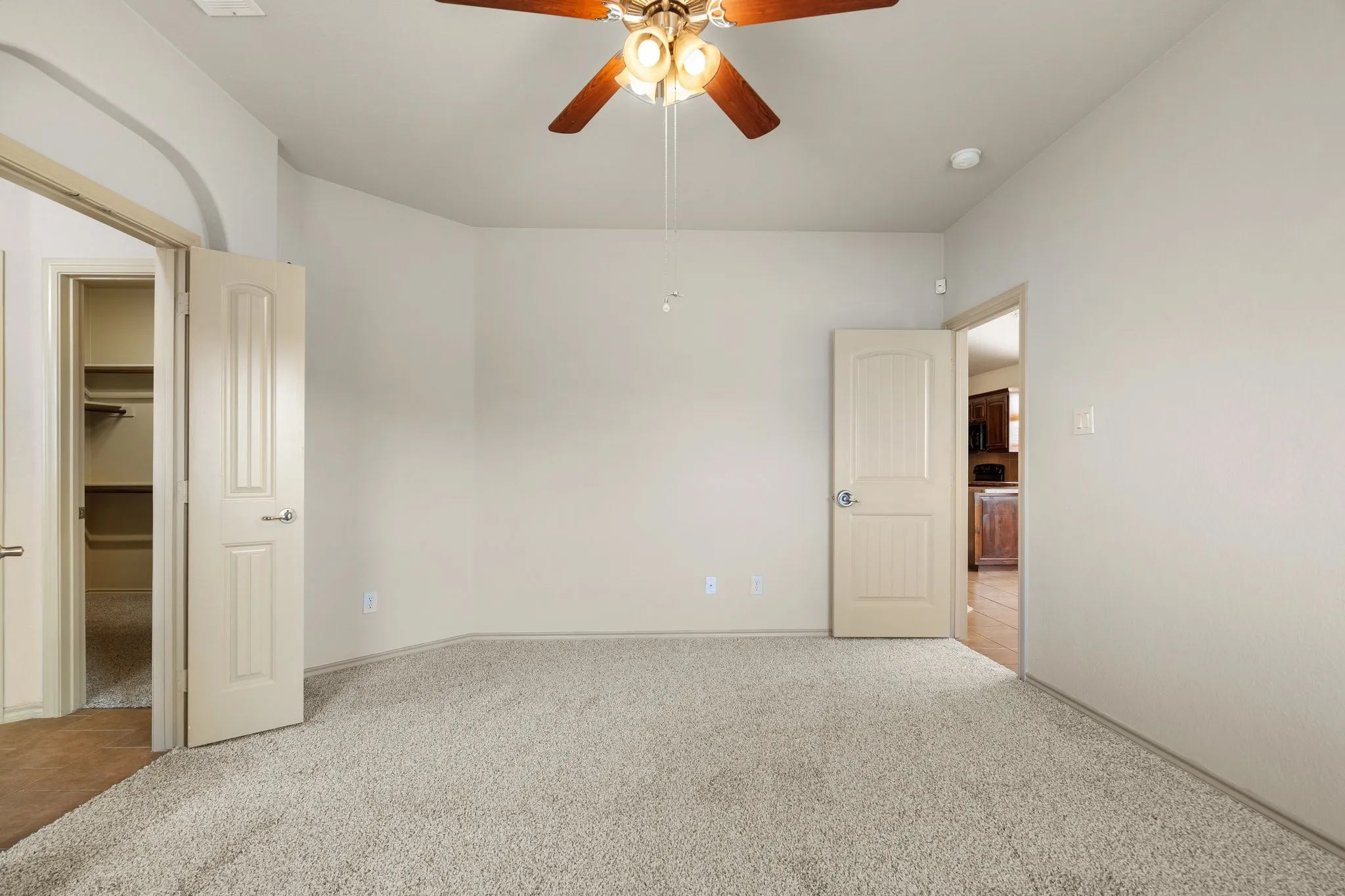 Empty room with ceiling fan and light tile floors