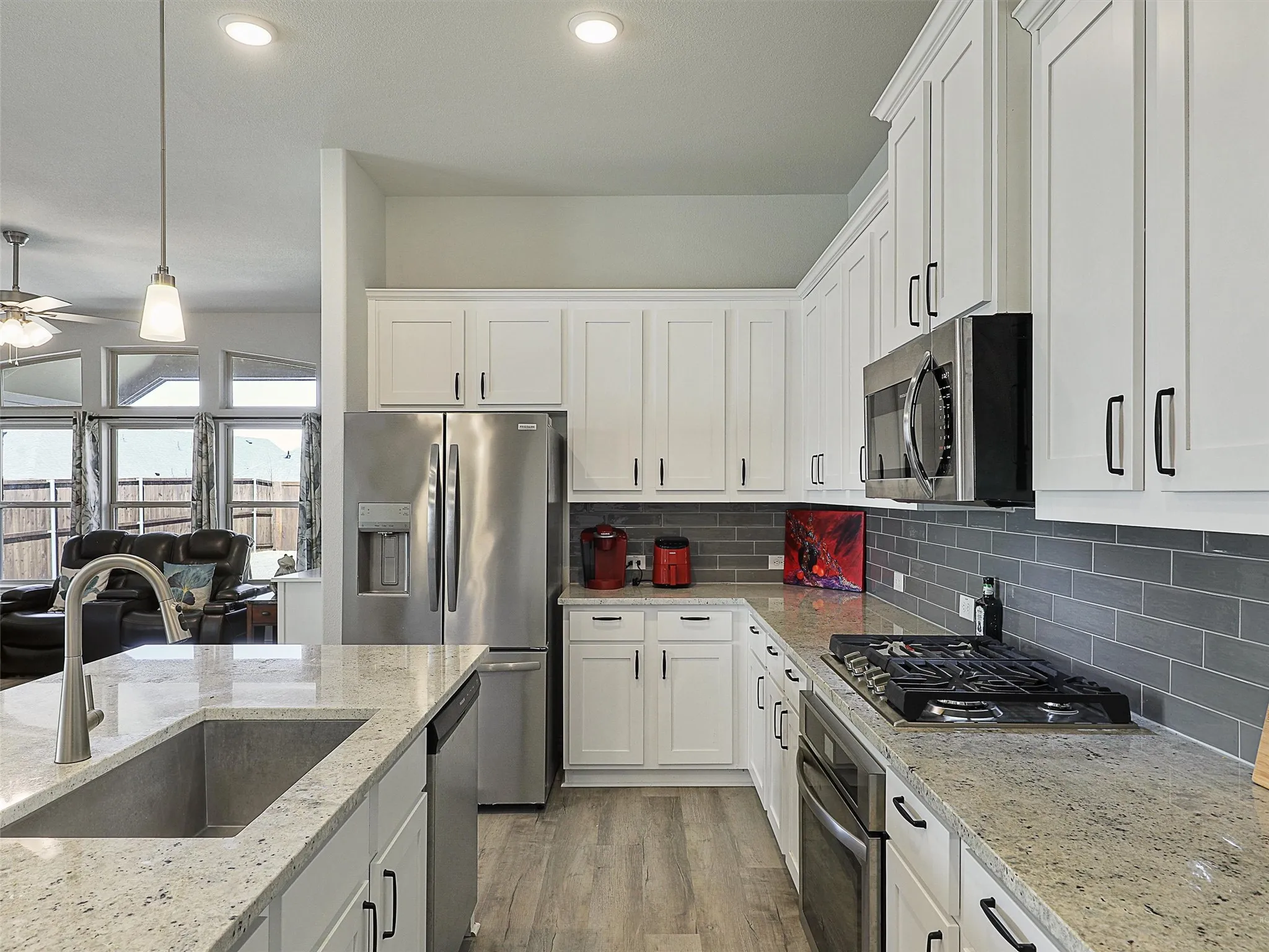 Open Kitchen with stainless appliances, gas cooktop and vented hood