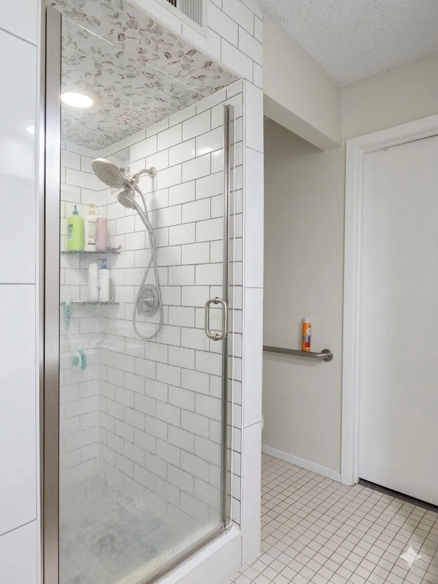 Glass-enclosed shower featuring white subway tile surround and a tiled ceiling accent