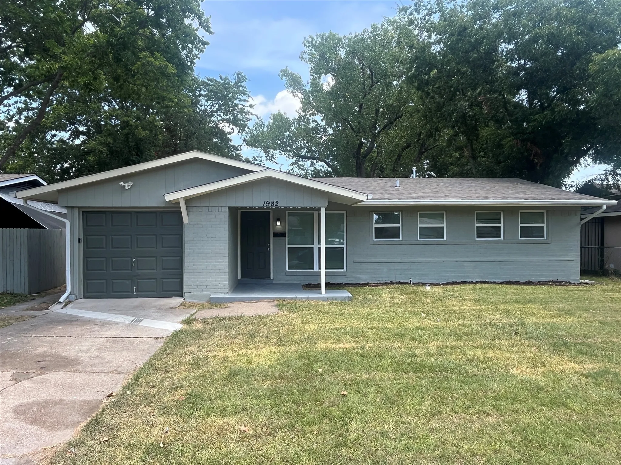 Ranch-style exterior with a gabled roof, attached garage, and a covered porch
