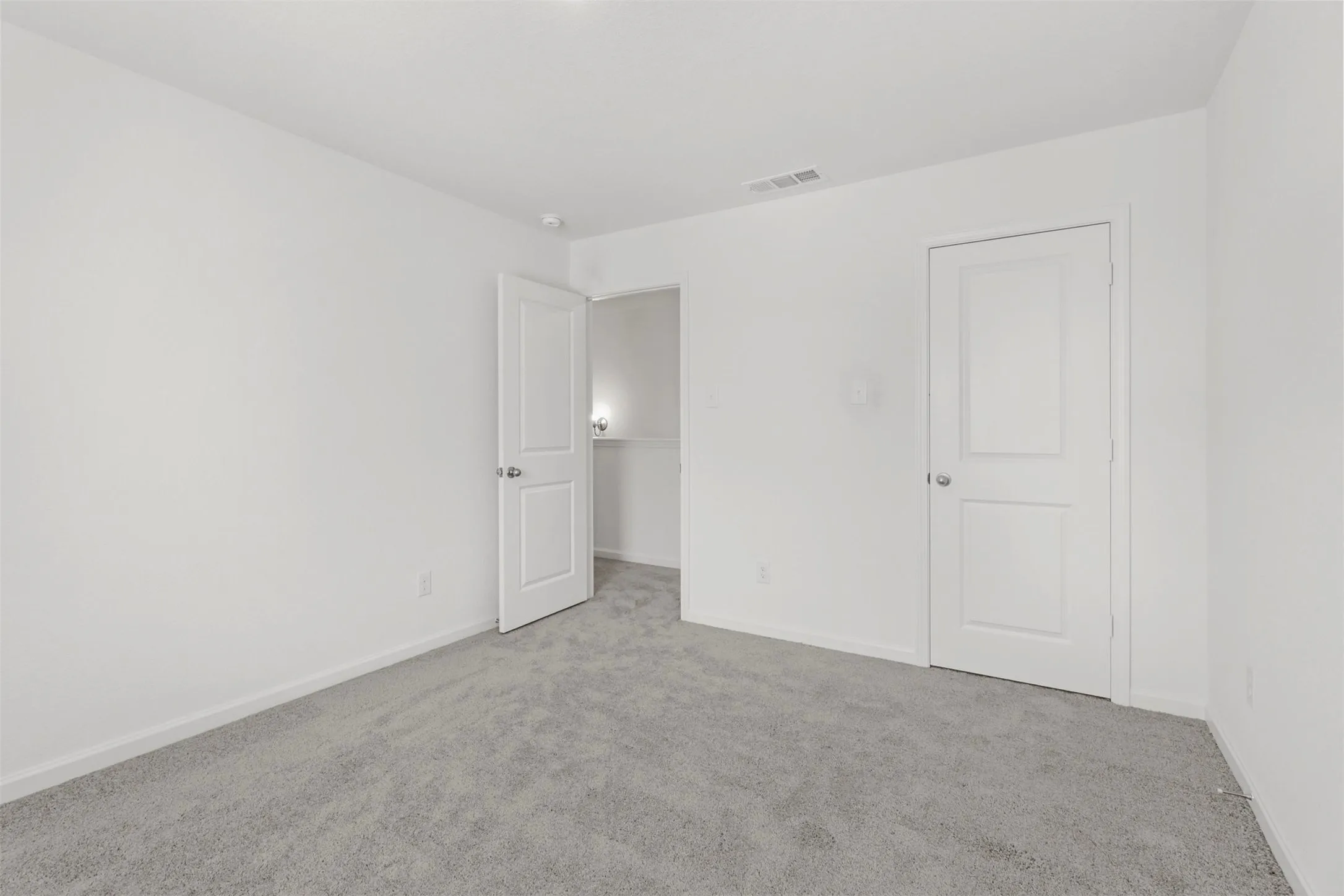 Room featuring light gray carpeting, crisp white walls, and bright white trim