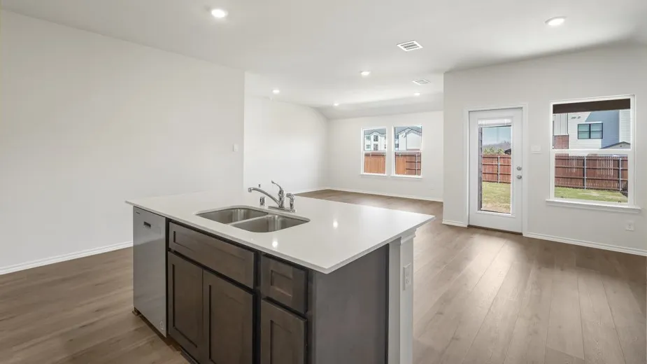 Kitchen island featuring a double-basin stainless steel sink, chrome faucet, and integrated dishwasher