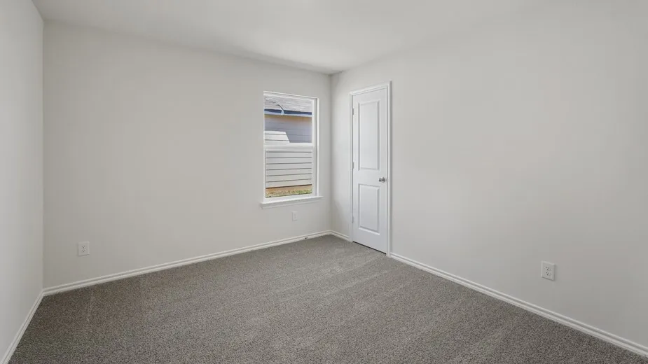 Bedroom featuring neutral wall paint, gray carpet flooring, white baseboards, and a white two-panel door