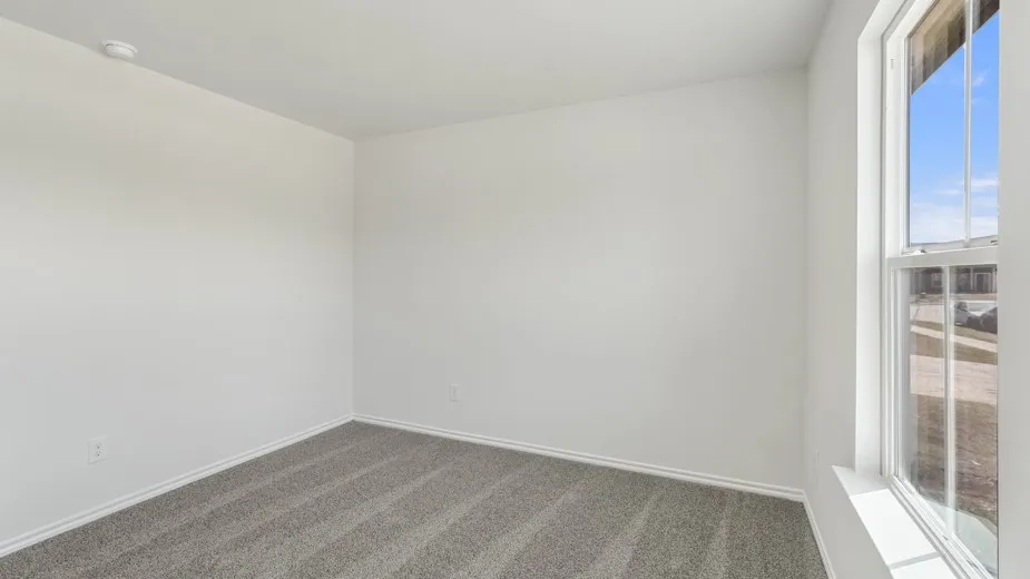 Room with light gray wall paint, gray carpet, and a single-pane window