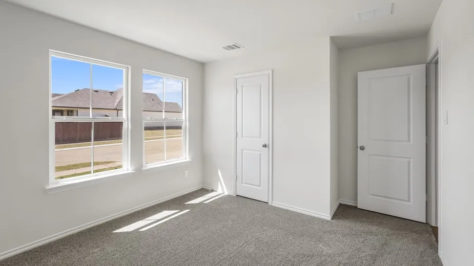 Carpeted room featuring two white-framed windows, white walls, and a matching white interior door