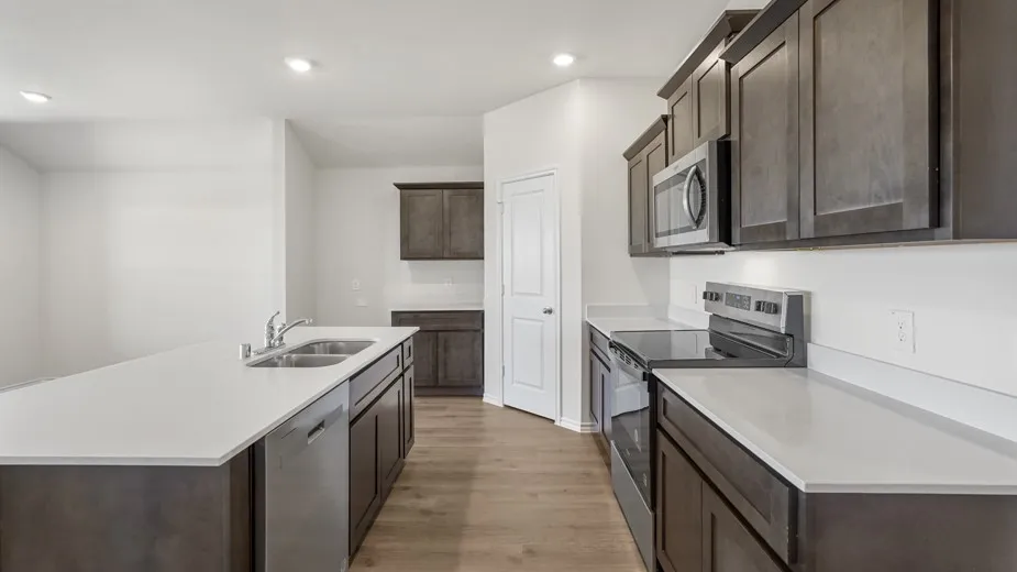 Kitchen featuring white countertops, dark wood-finish cabinetry, stainless steel appliances, and wood-finish flooring