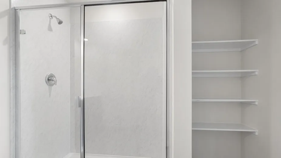 Walk-in shower with clear glass enclosure and chrome fixtures