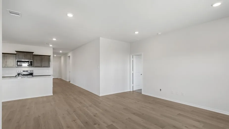 Open-concept living area featuring wood-finish flooring, recessed lighting, and a neutral color palette