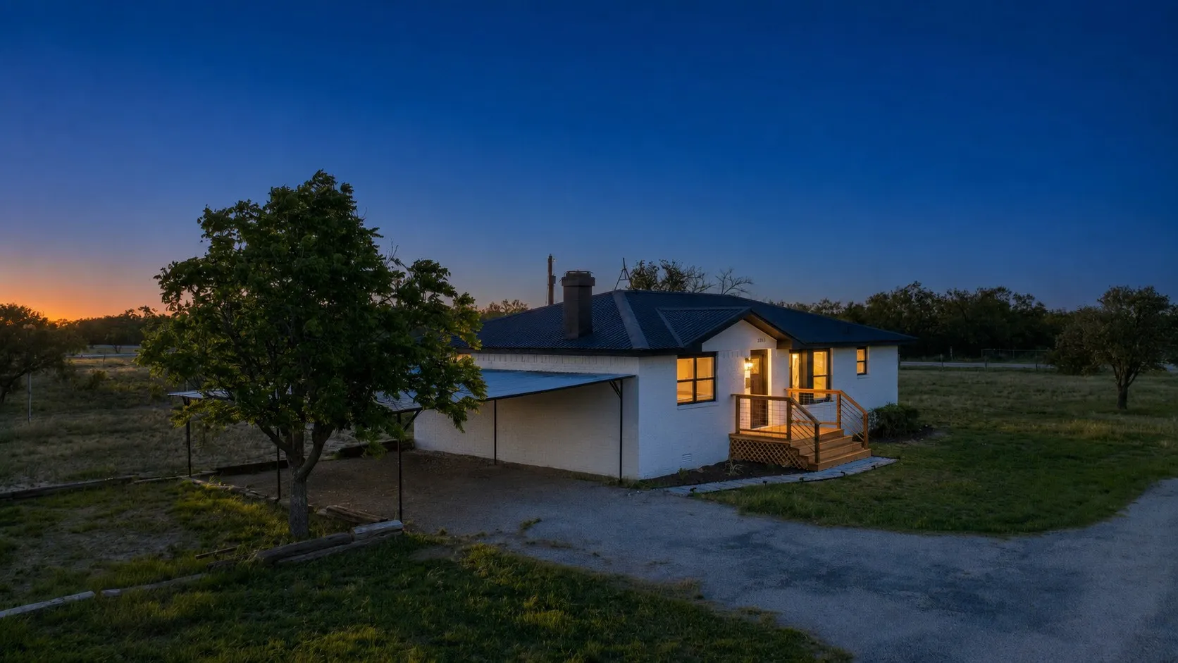 White single-story residence featuring a dark-pitched roof and a contrasting light-colored façade