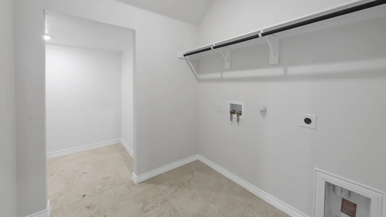 Dedicated laundry area featuring a wall-mounted shelving unit, clothing rod, and tile flooring